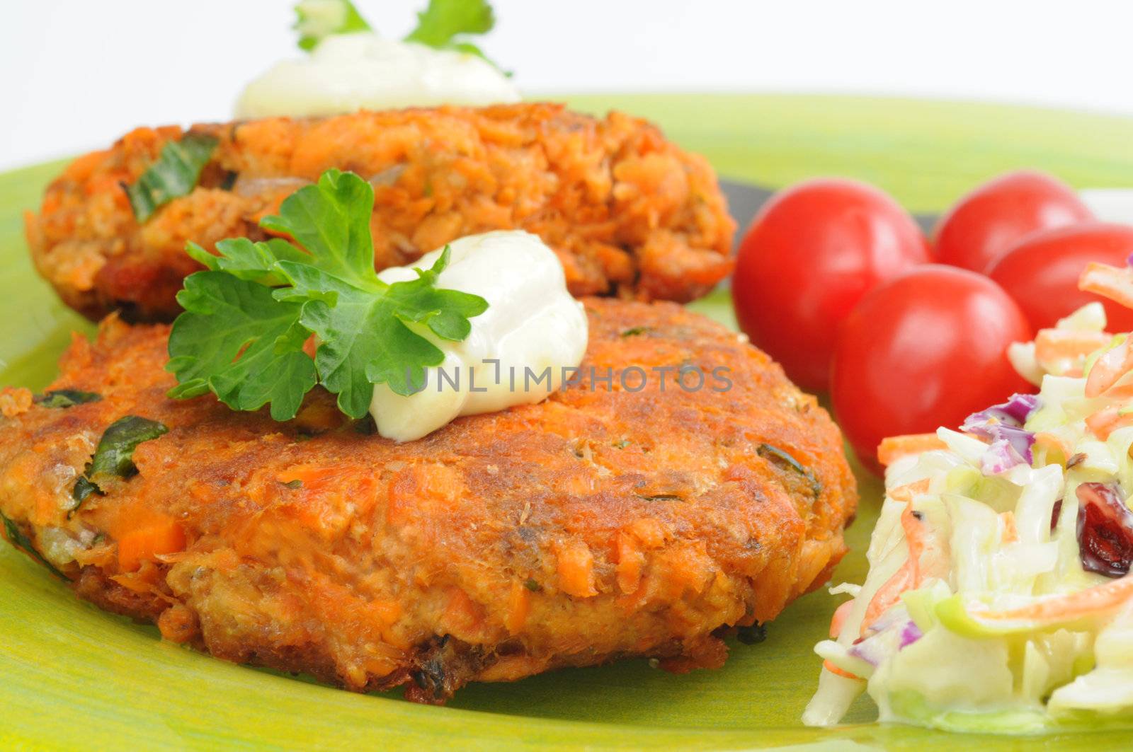 Delicious homemade salmon burgers served with vegetables.