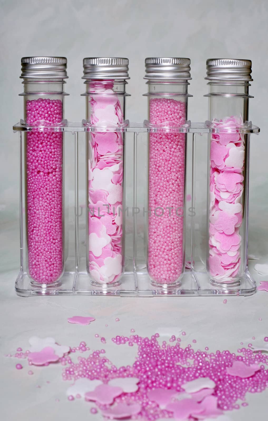 Four bottles with pink salt for baths in a transparent support