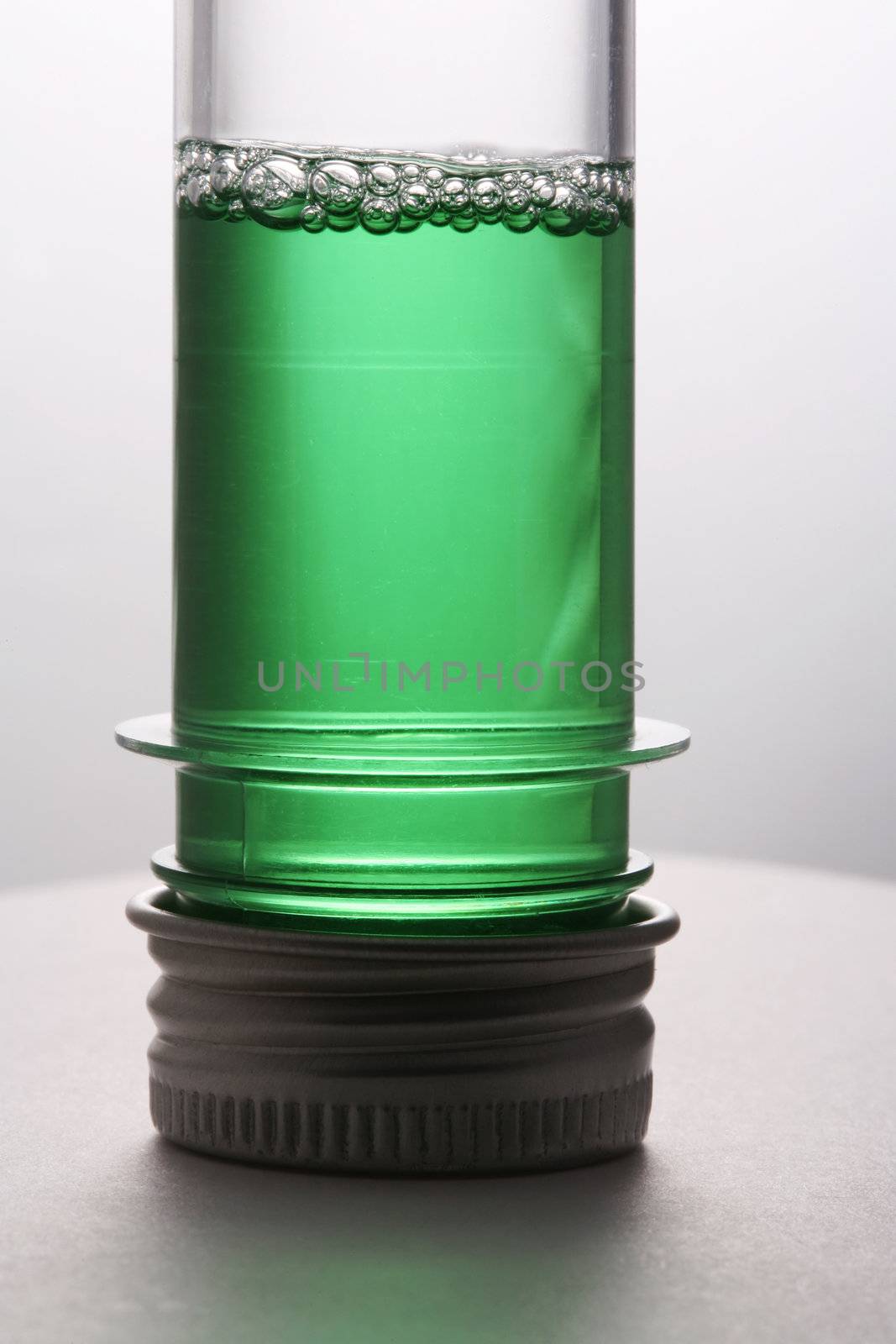 Test tube with a green liquid on a white background