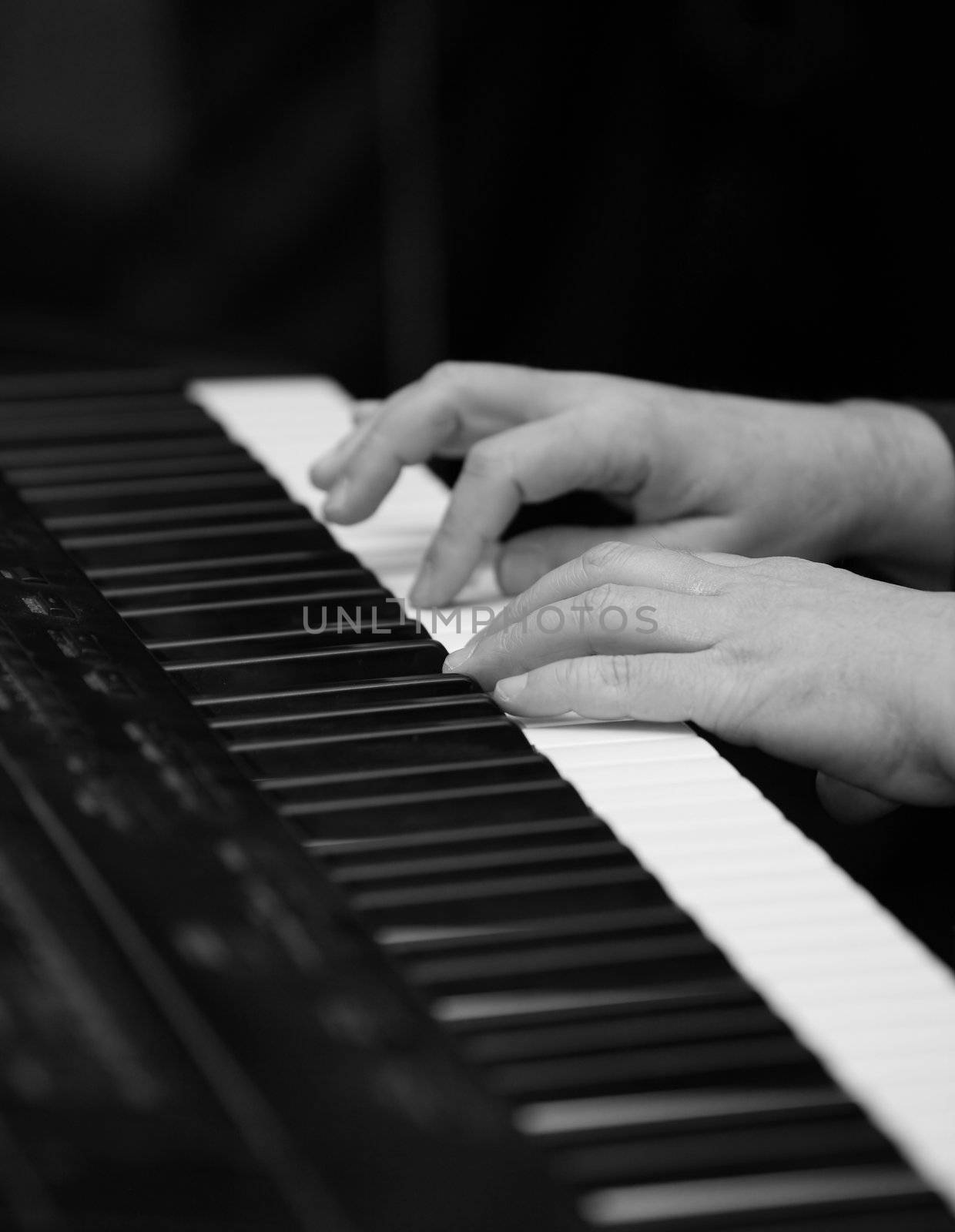The man plays on a piano. b/w 