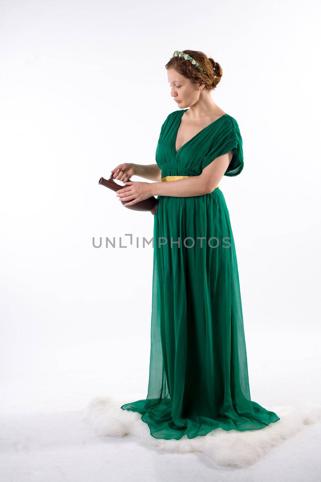 Lady in green antique dress handing jug on white background
