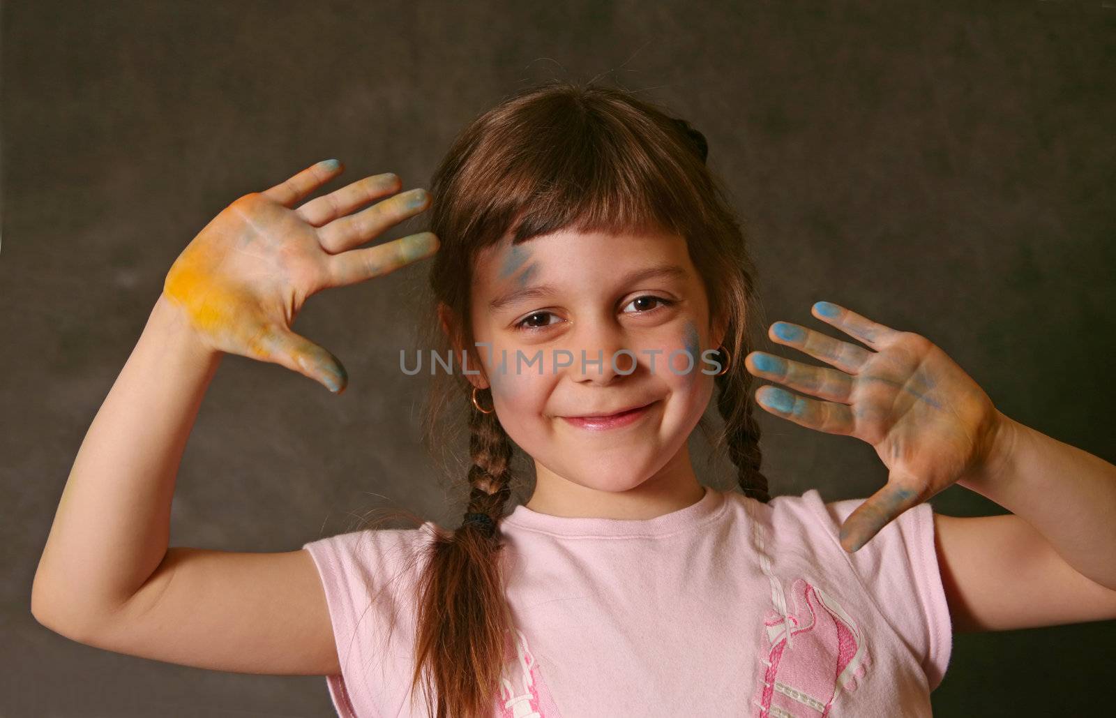The good little girl. Hands and the face are soiled in a paint