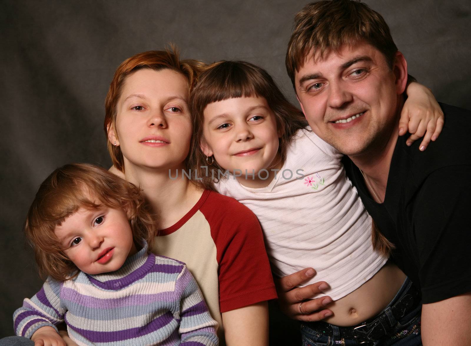 Family portrait on a dark background in studio