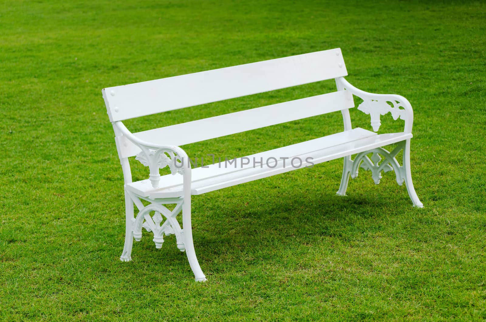 White Bench on green lawn in the garden