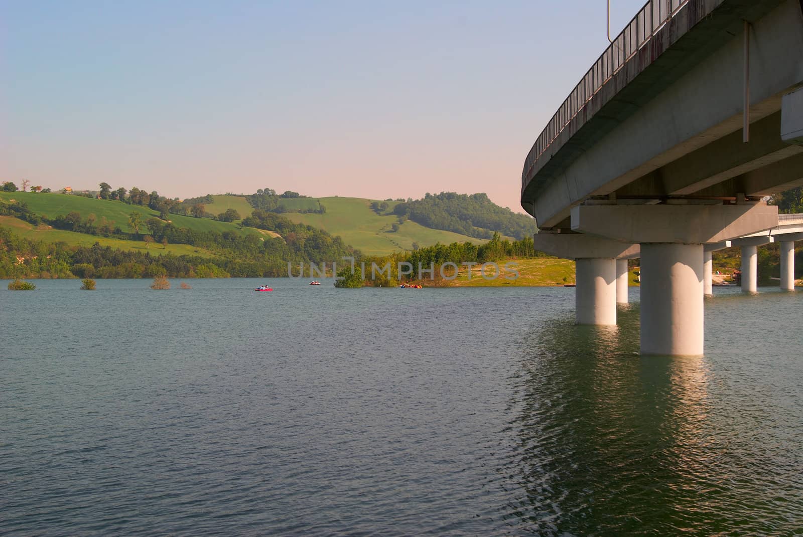 Panoramic sunset landscape lake in Italy and the bridge