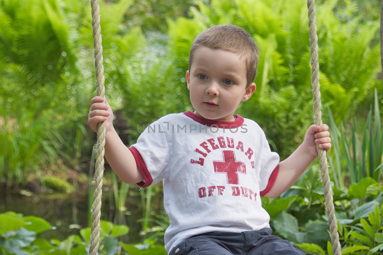 Cute little boy thoughtful on a swing