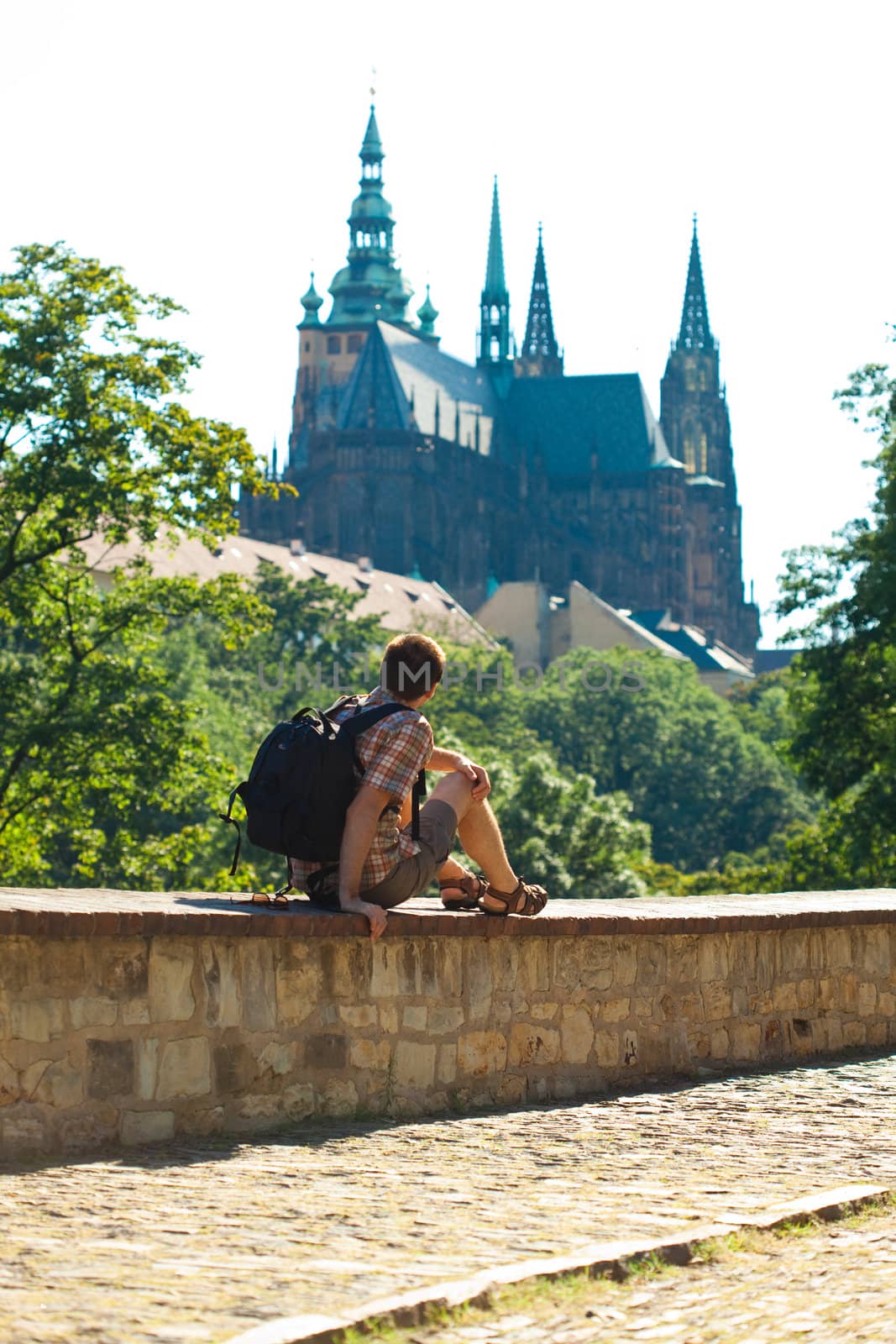 man sitting on a background of St. Vitus Cathedral in Prague