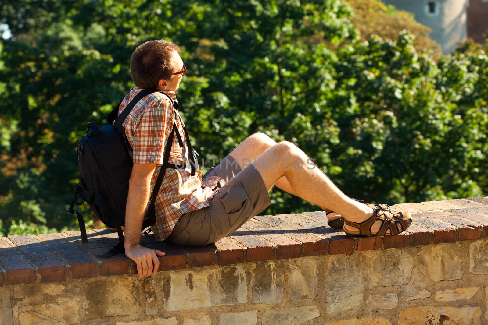 man sitting on a background of green foliage in Prague