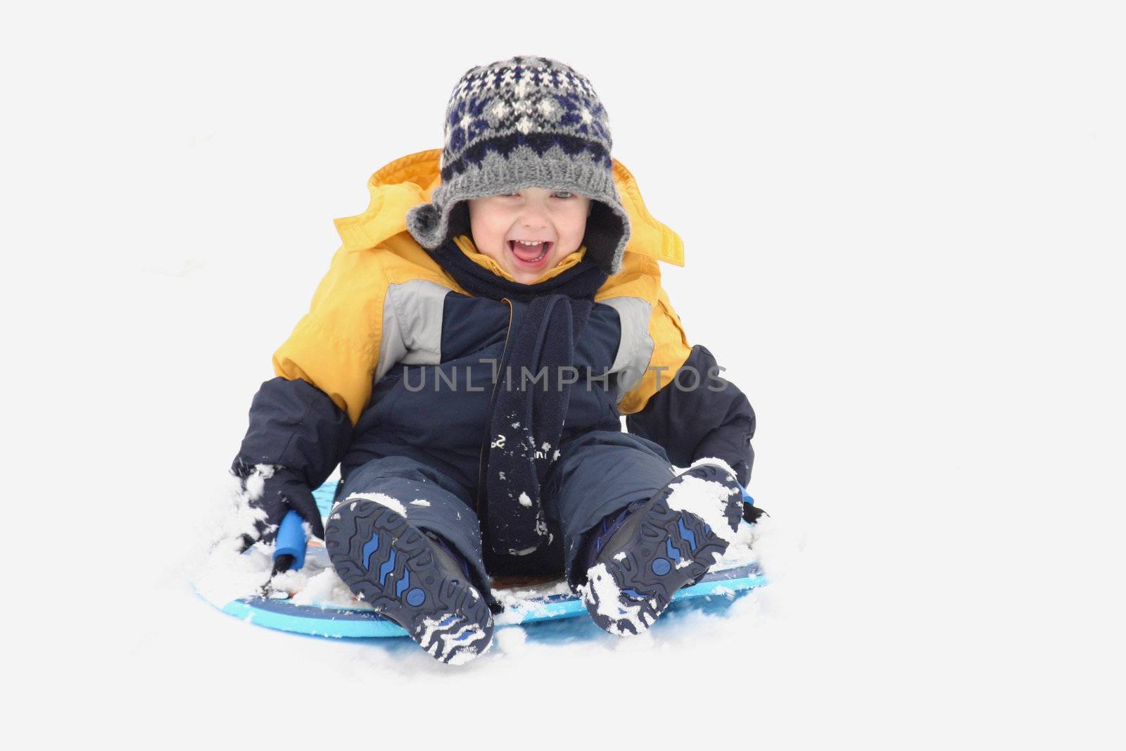 Little boy sliding in the snow