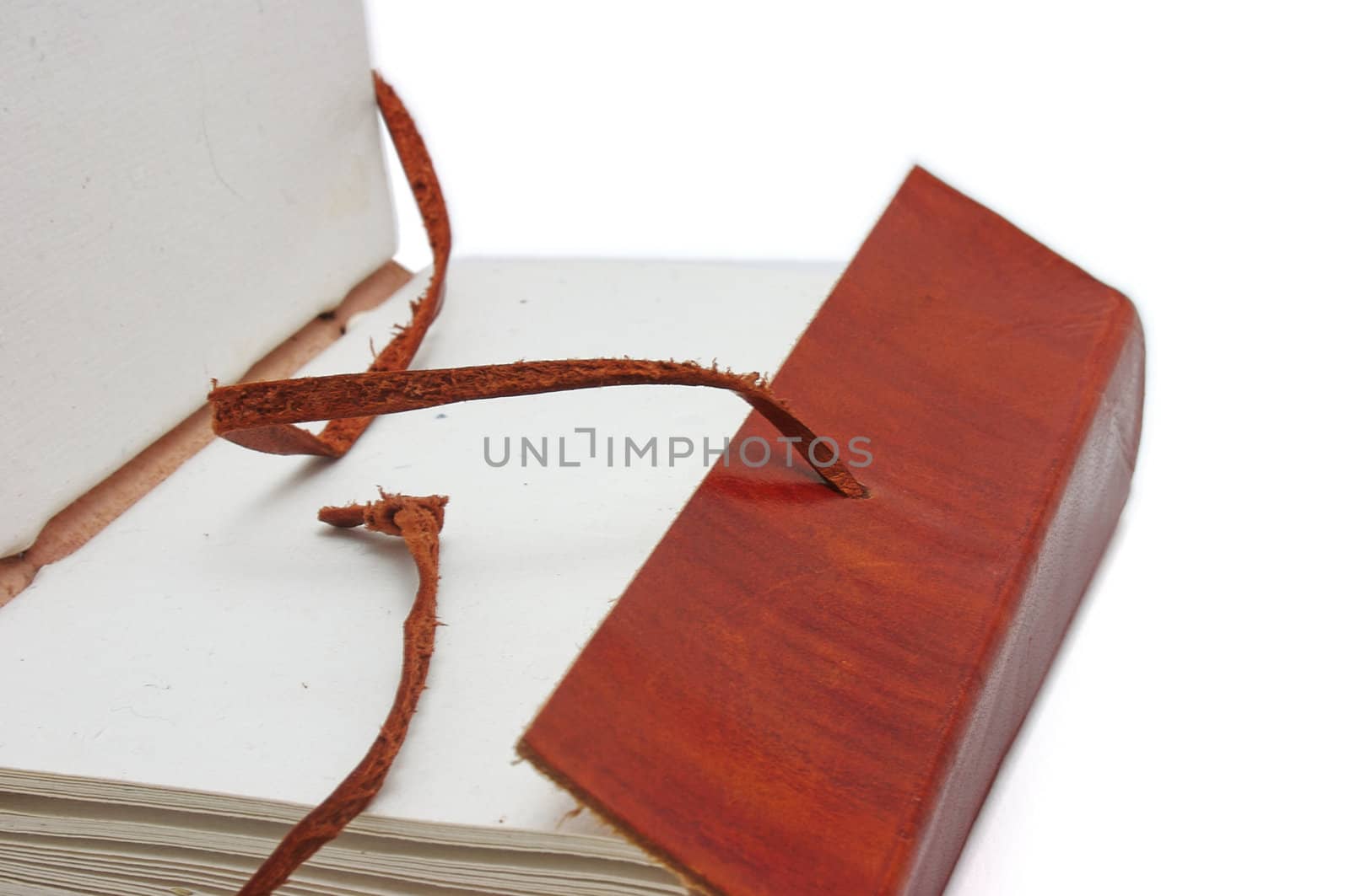 Old leather-bound book with parchment paper inside on a white background
