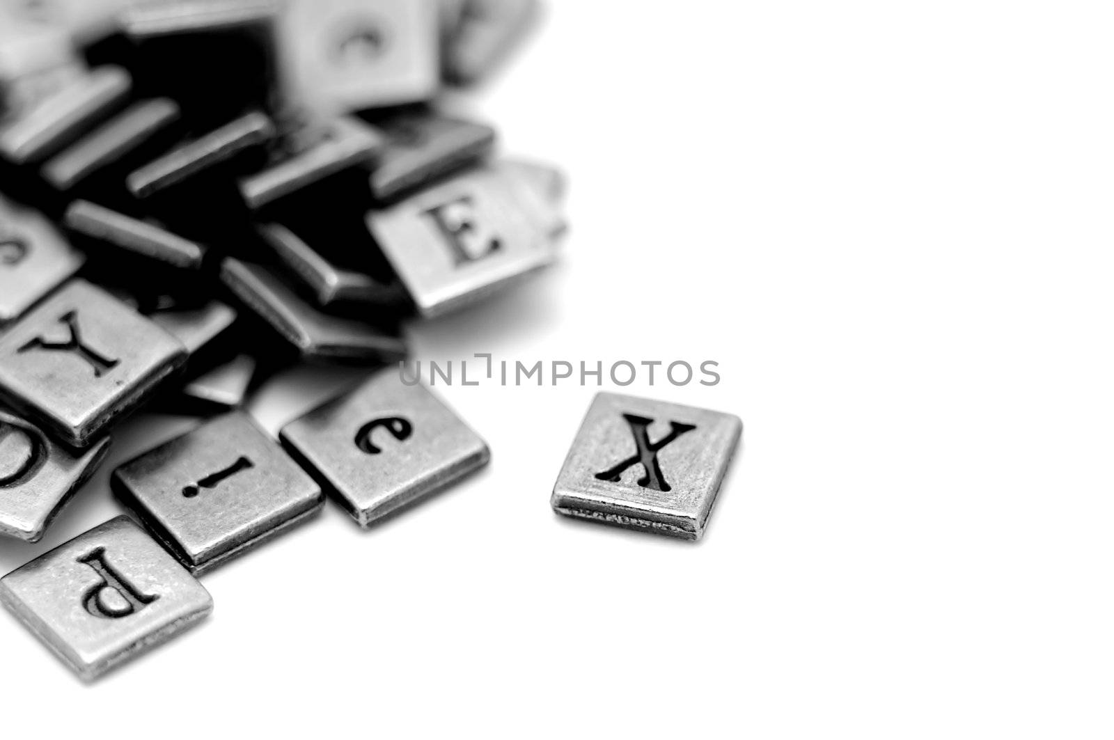 Metal scrapbooking letters laying on a white background.