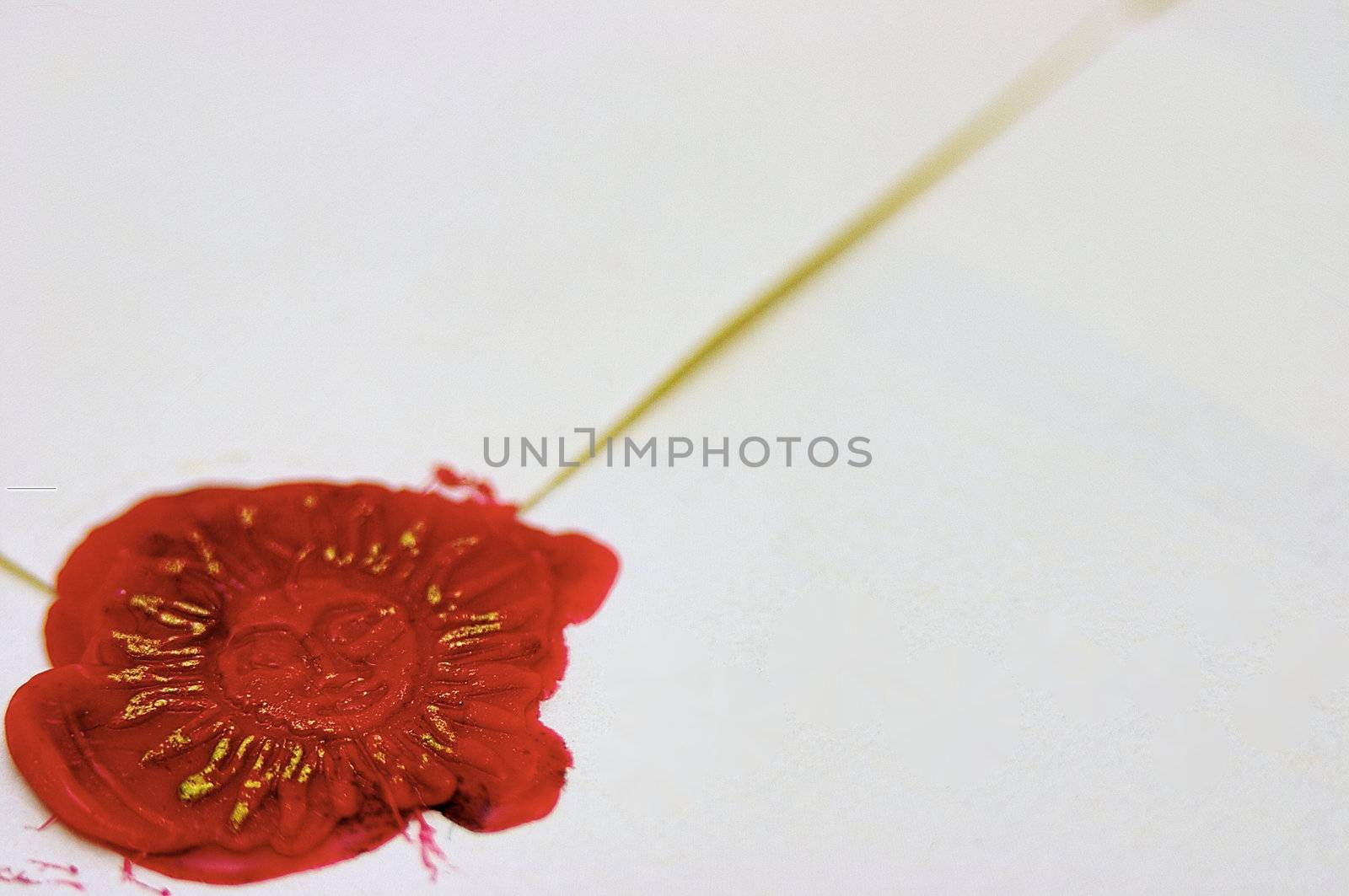 Signet stamped in red wax and gold ink to seal a parchment envelope