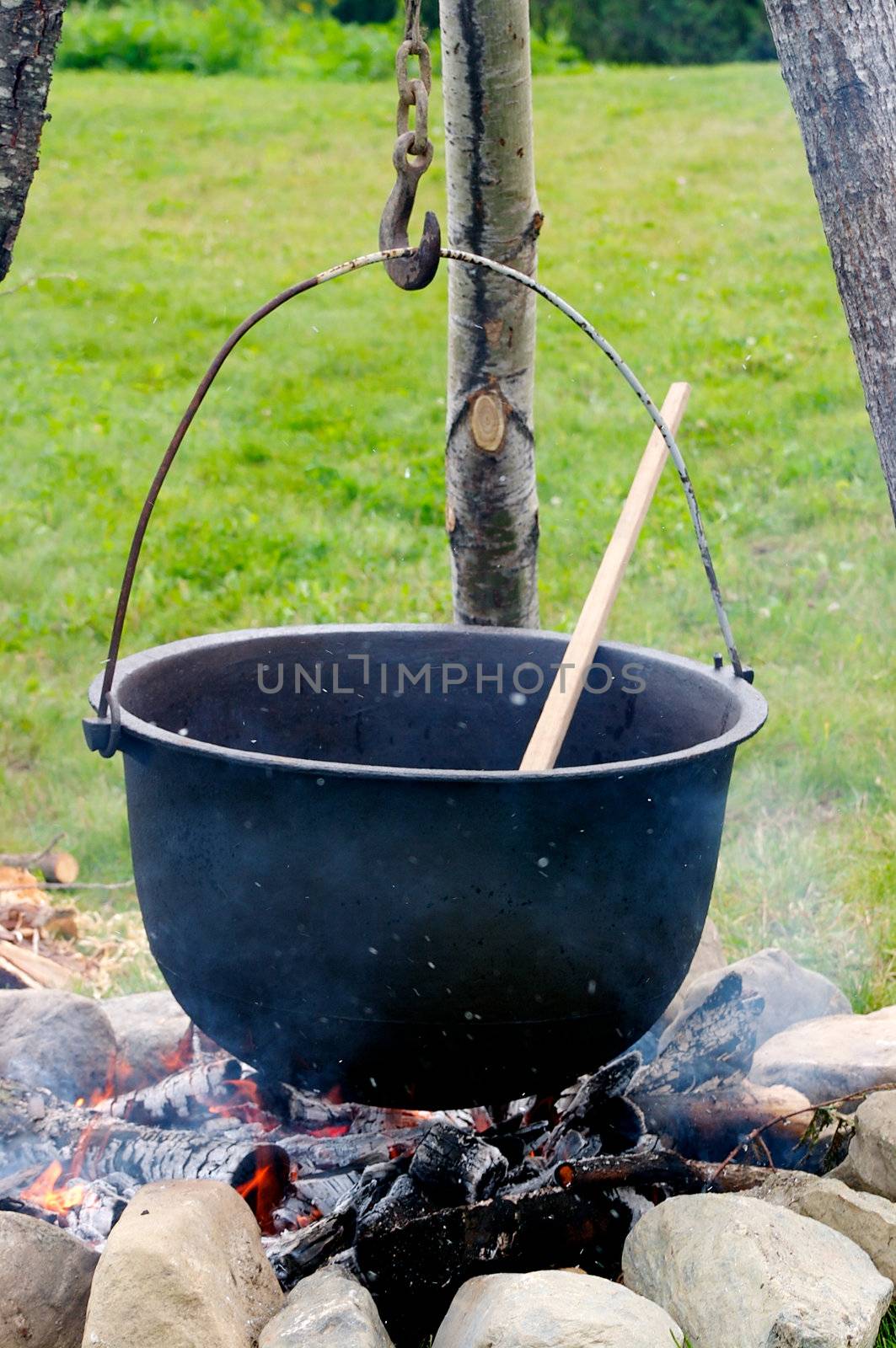 Old pot with a spoon over a fire