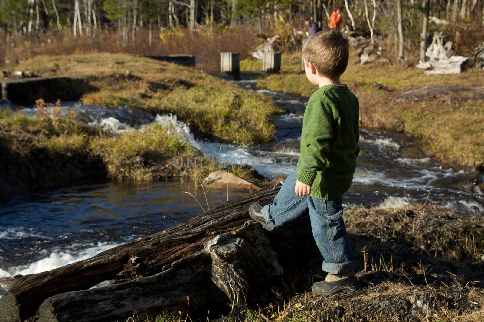 Cute little boy standing by a river