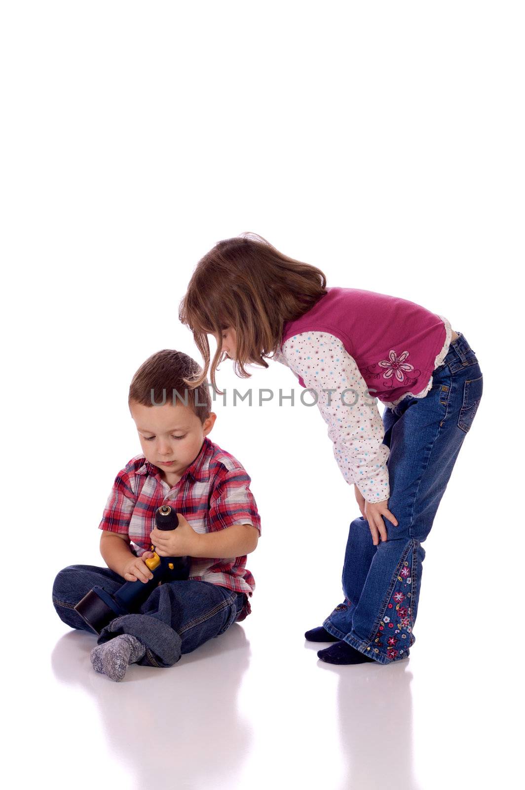 Cute little girl watching his brother with a drill