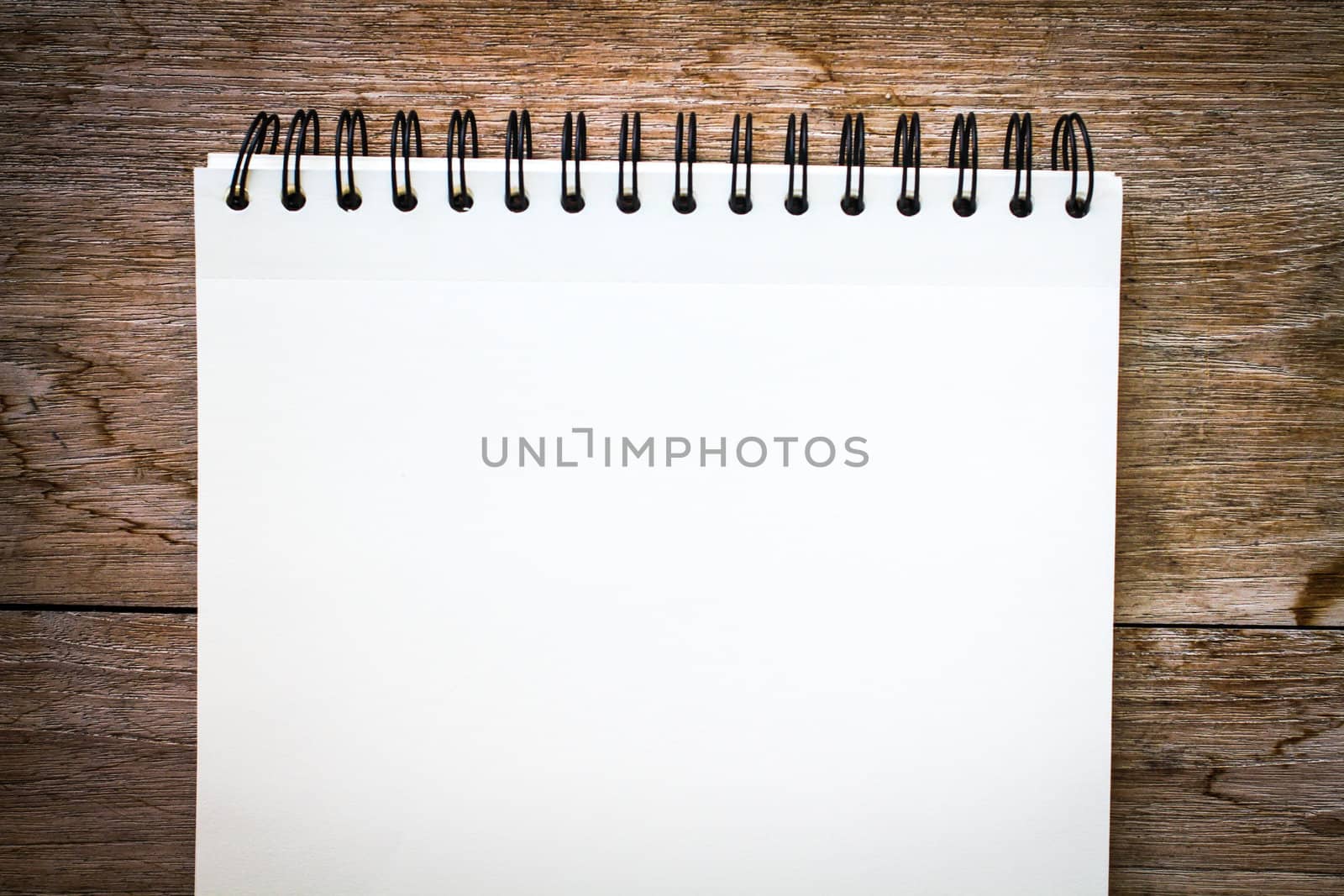 white notebook on the wood backgroung with pink flower