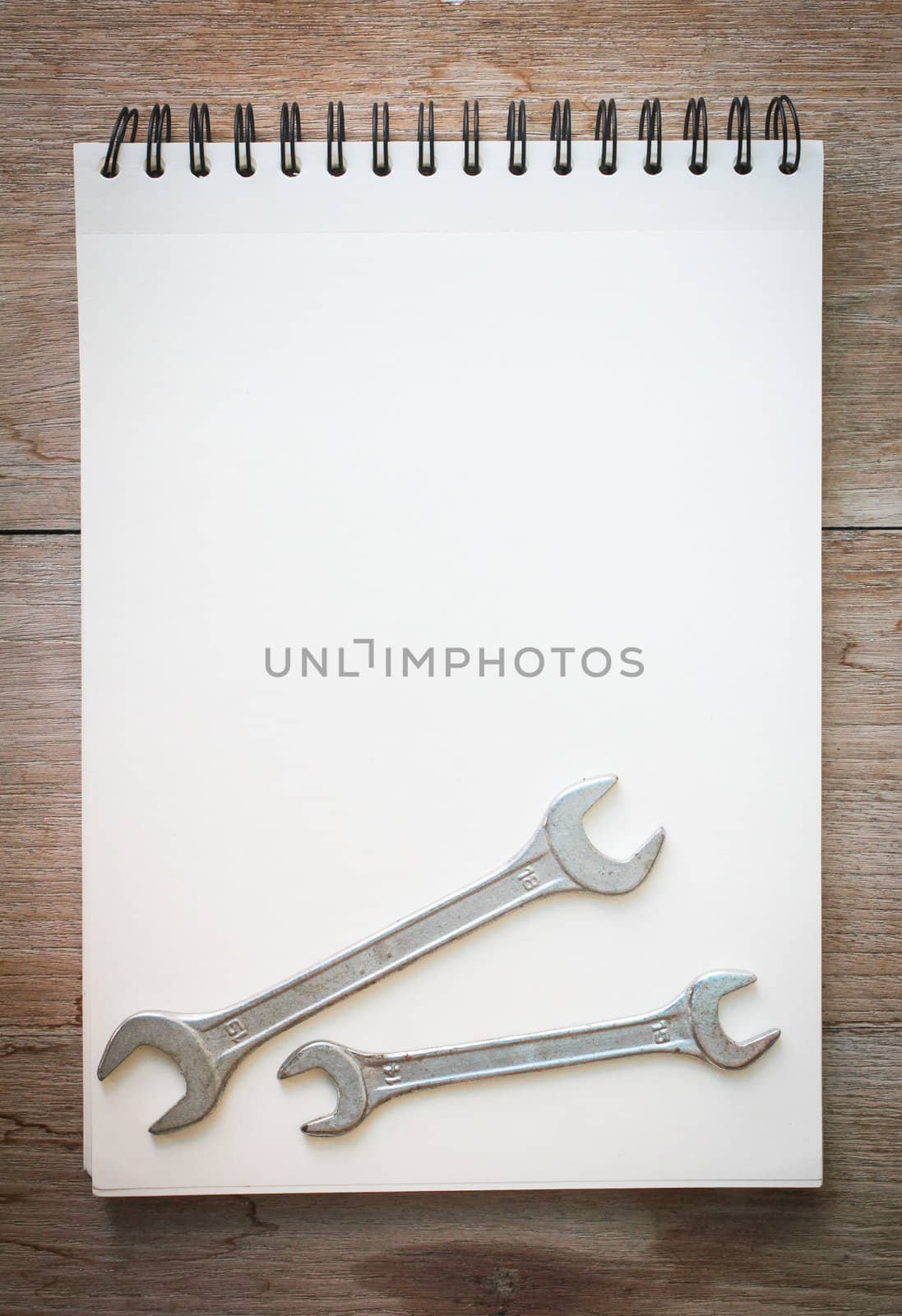 white notebook on the wood backgroung with pink flower