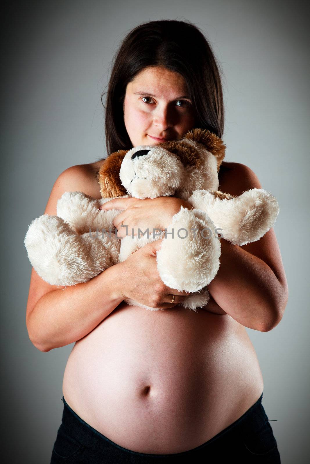 32 weeks pregnant woman holding a teddy bear
