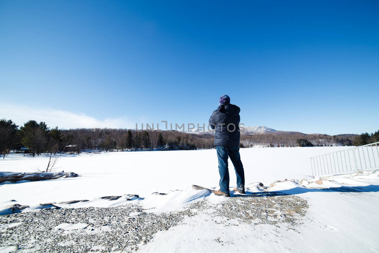 Man standing by a frozen lake