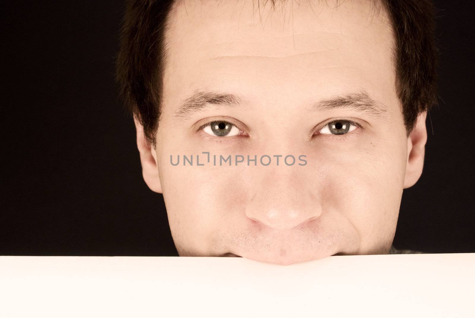 portrait of a man holding a paper in the teeth