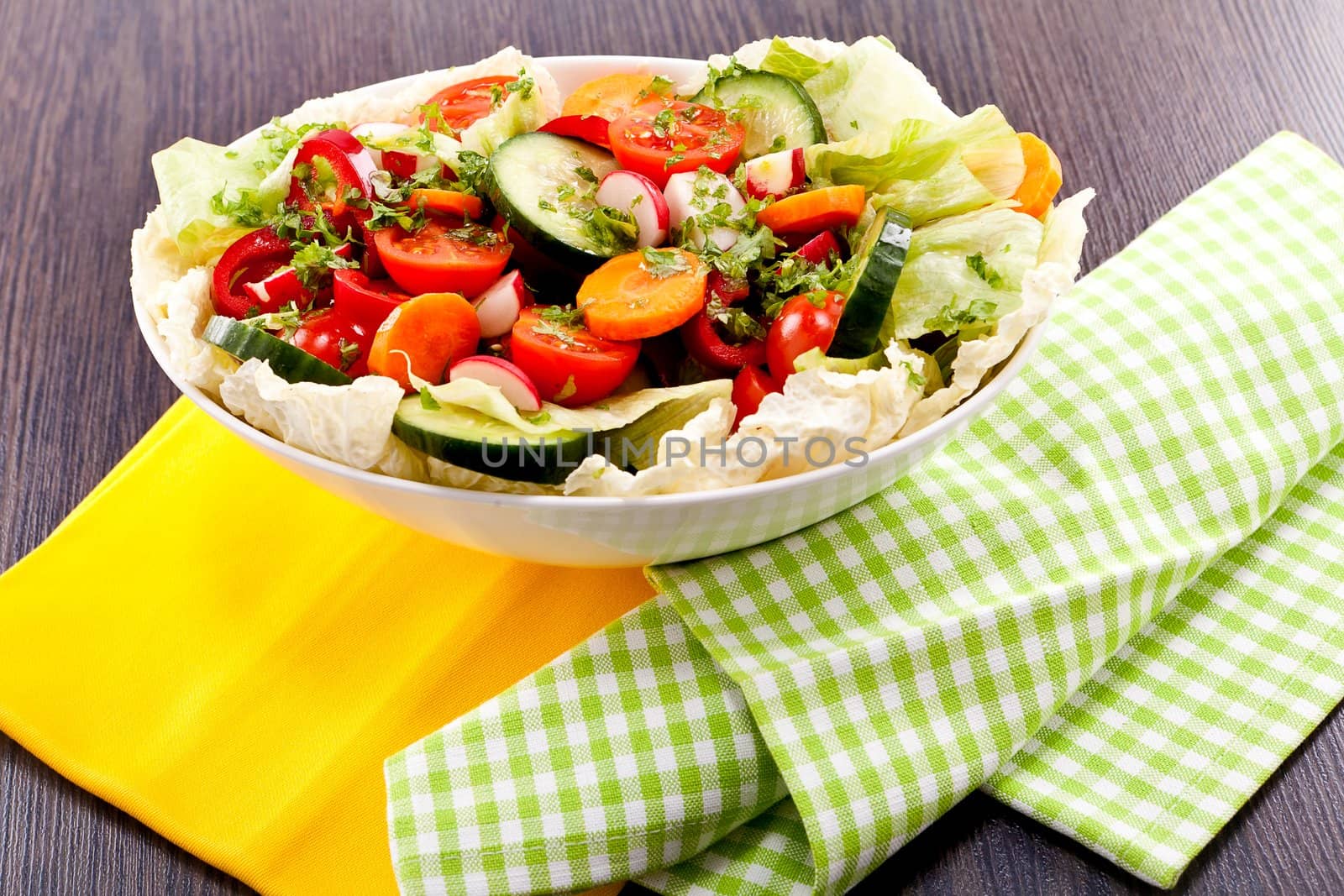 fresh mixed colorful salad on wooden table with green and yellow decoration