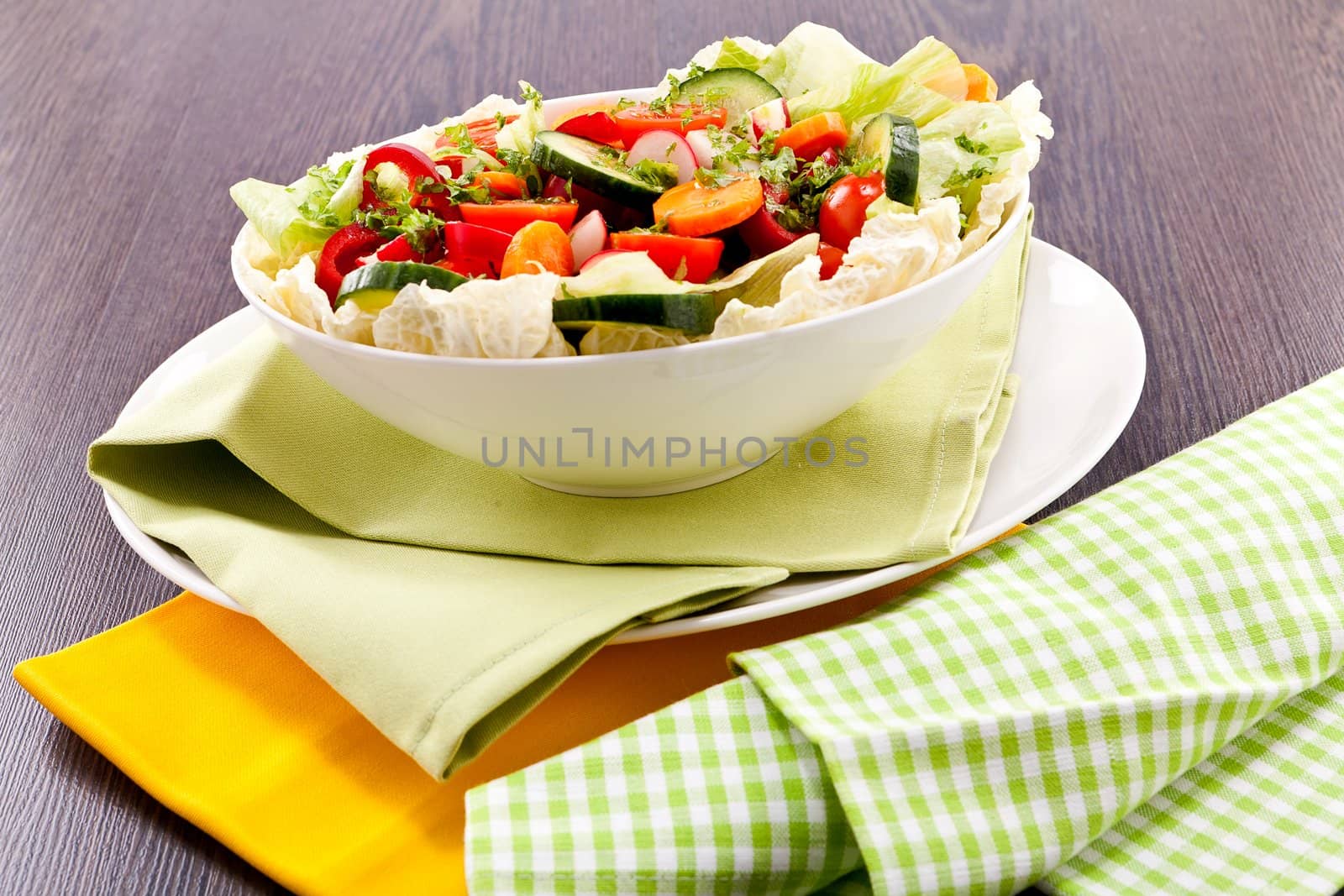 fresh mixed colorful salad on wooden table with green and yellow decoration