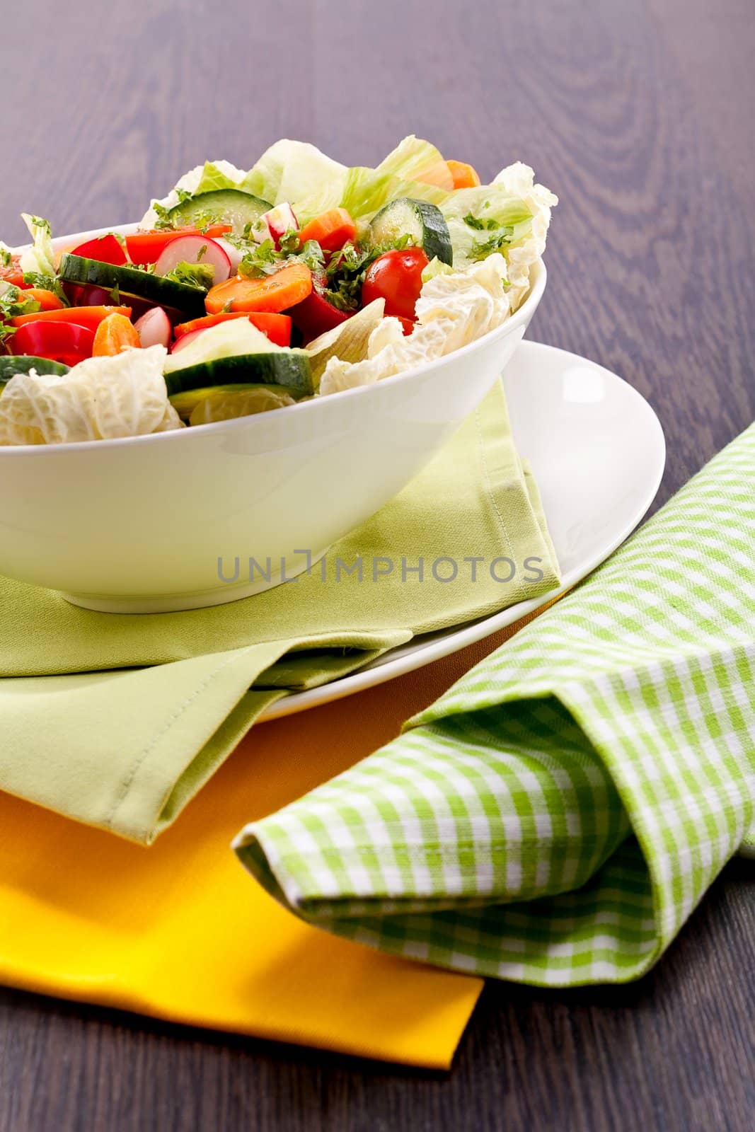 fresh mixed colorful salad on wooden table with green and yellow decoration