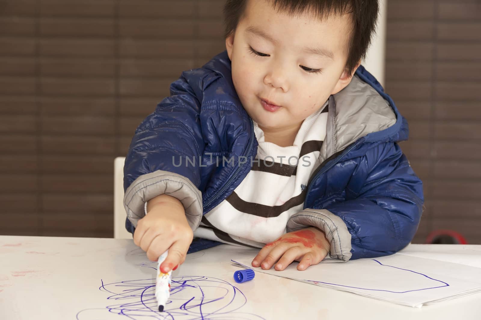 a cute baby is painting on the table by jackq