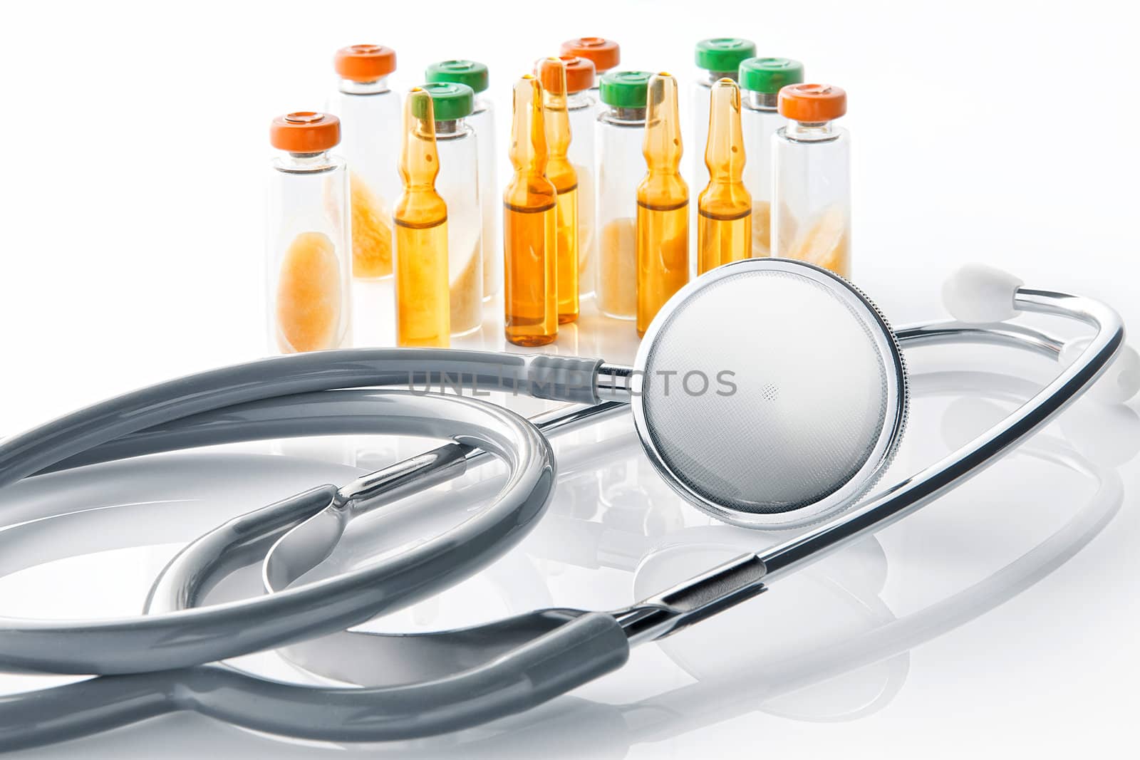 Close up view of grey stethoscope and ampoules  on white back by ersler