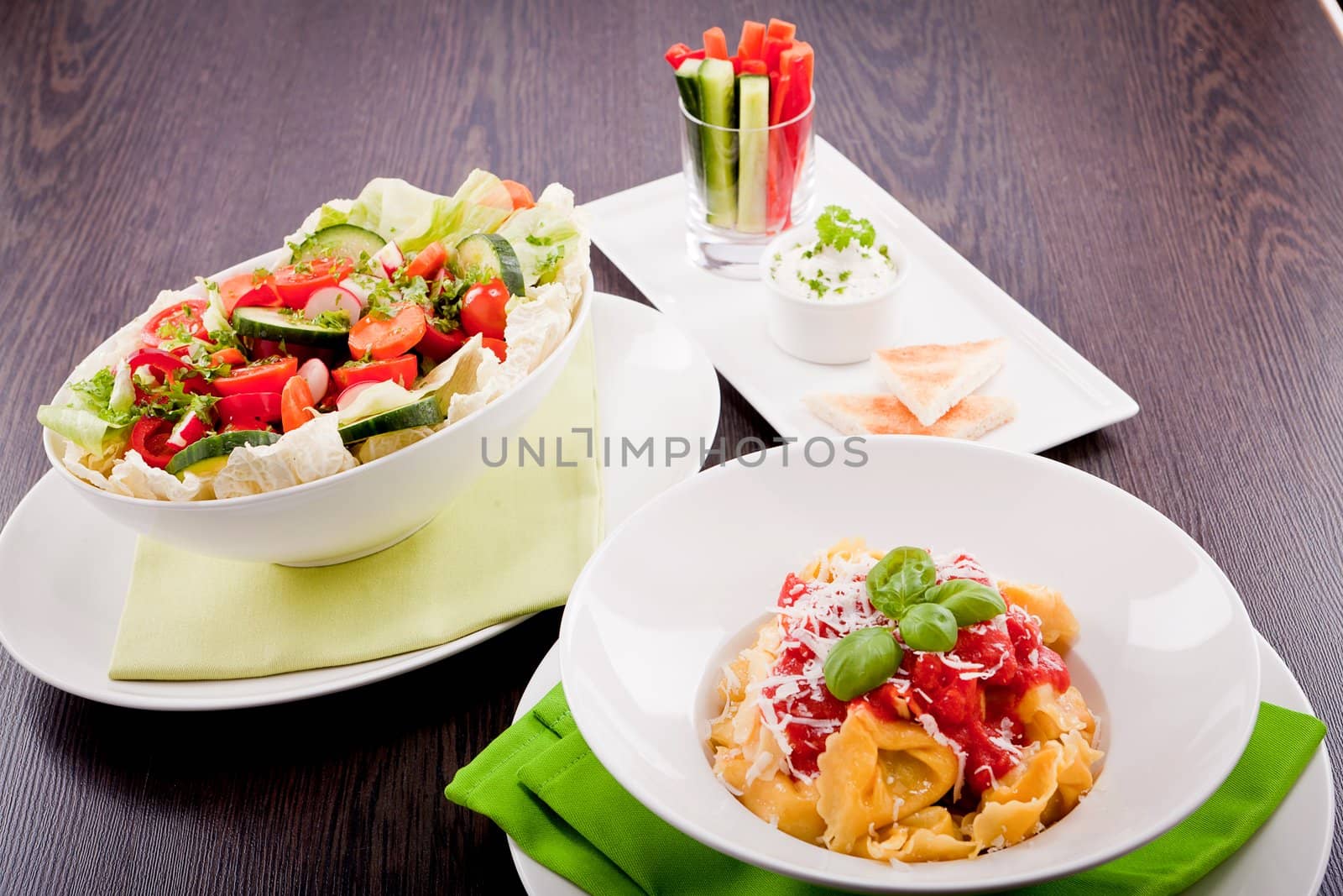 collection of different plates with healthy food pasta salad vegetables on wooden table