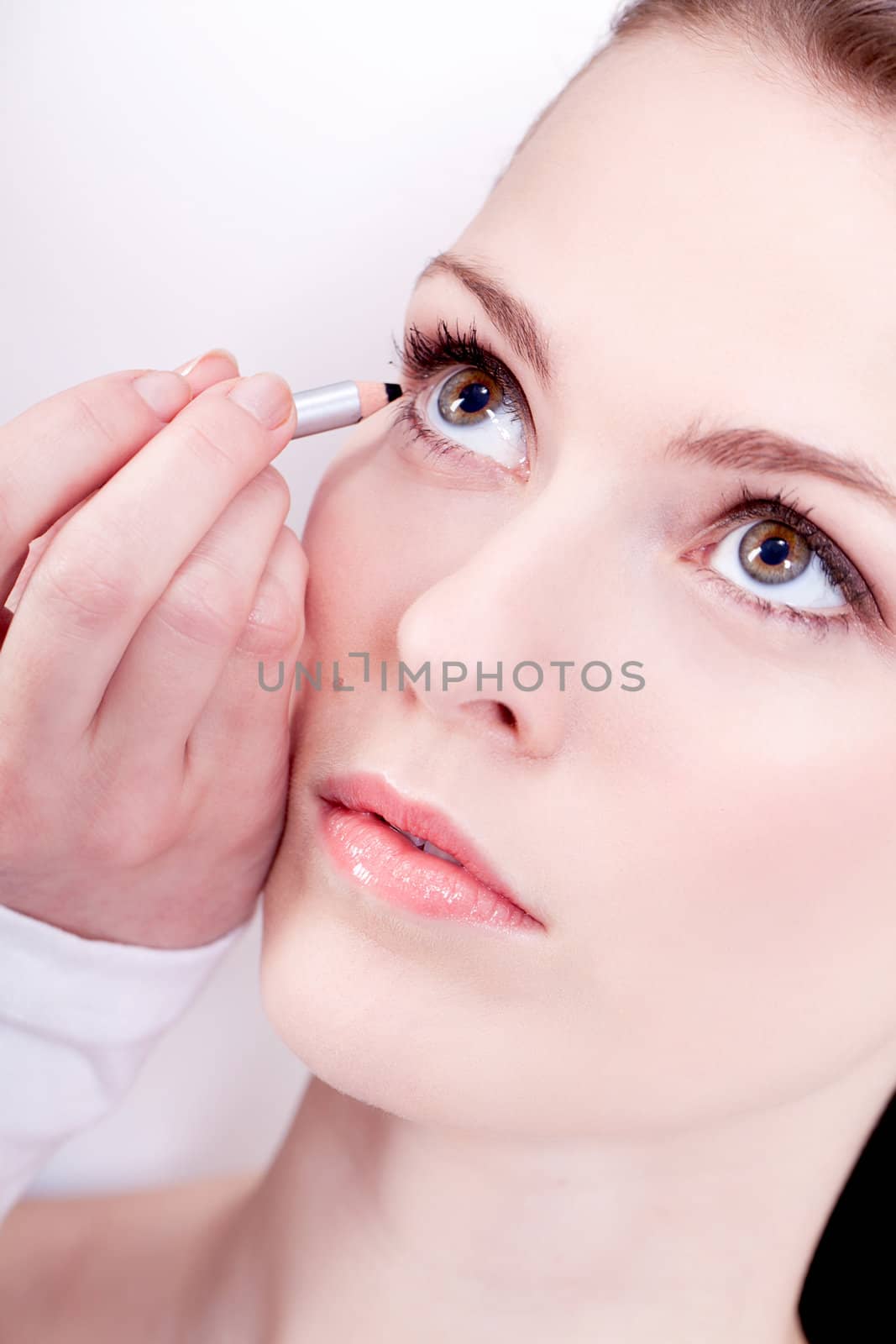 at the cosmetic studio eyeliner on eyes doing make up woman portrait closeup