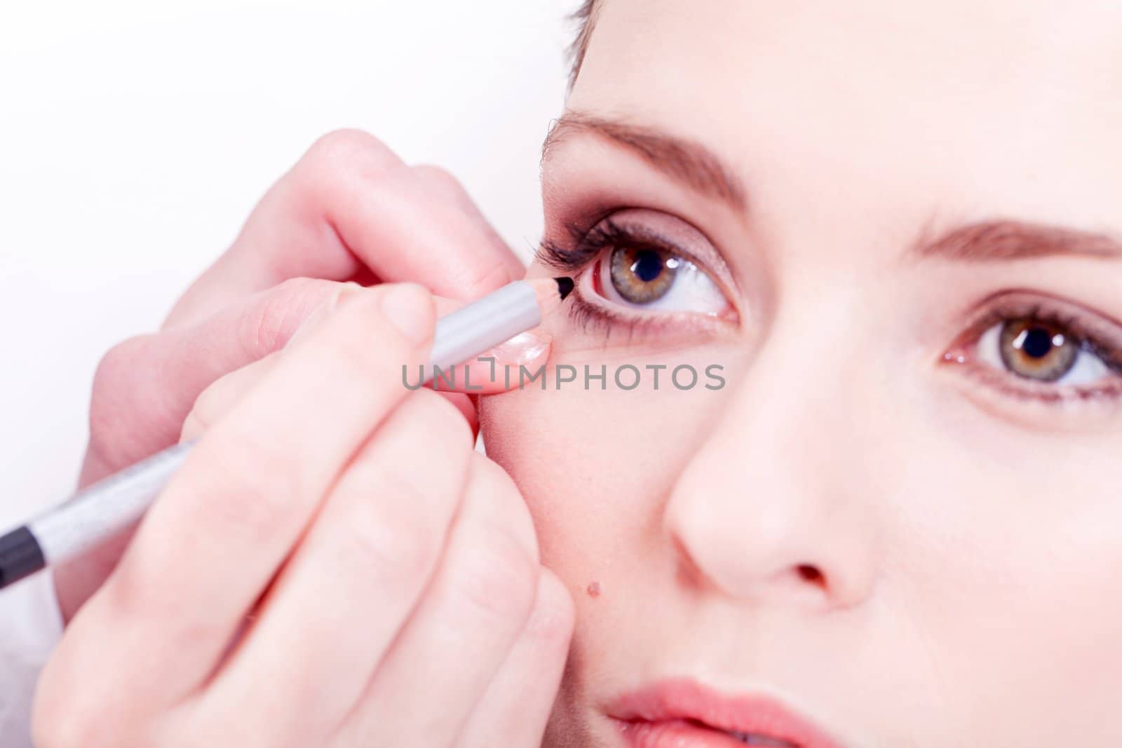 at the cosmetic studio eyeliner on eyes doing make up woman portrait closeup