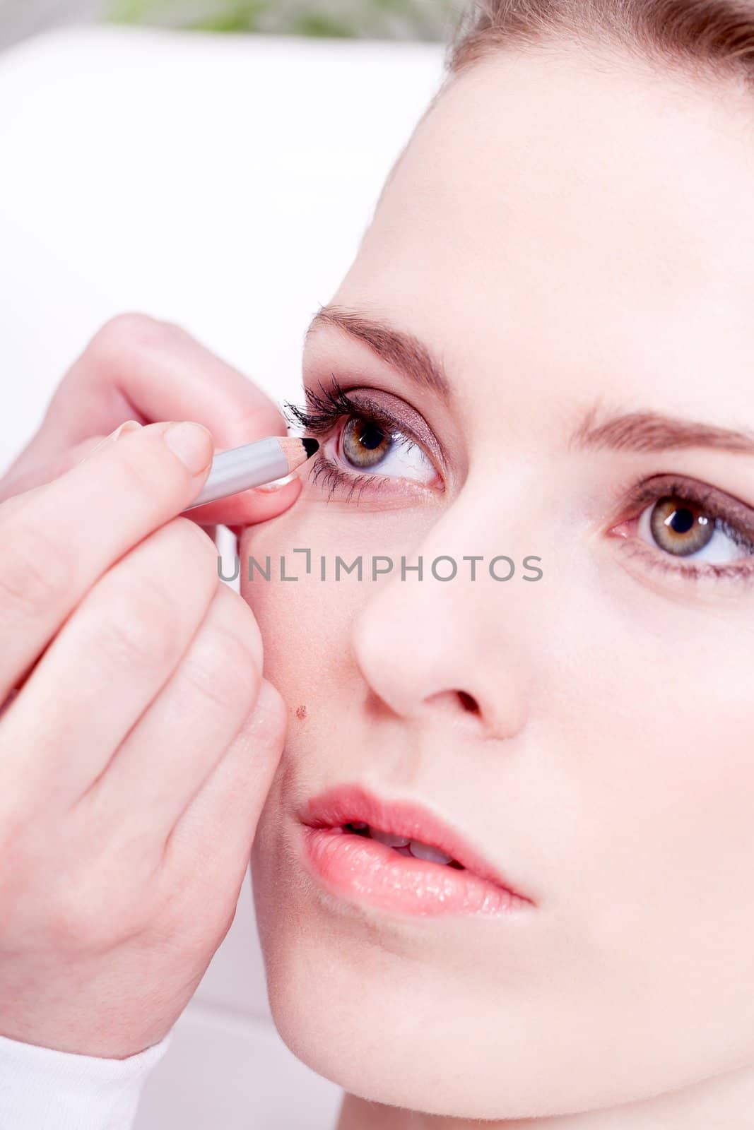 at the cosmetic studio eyeliner on eyes doing make up woman portrait closeup