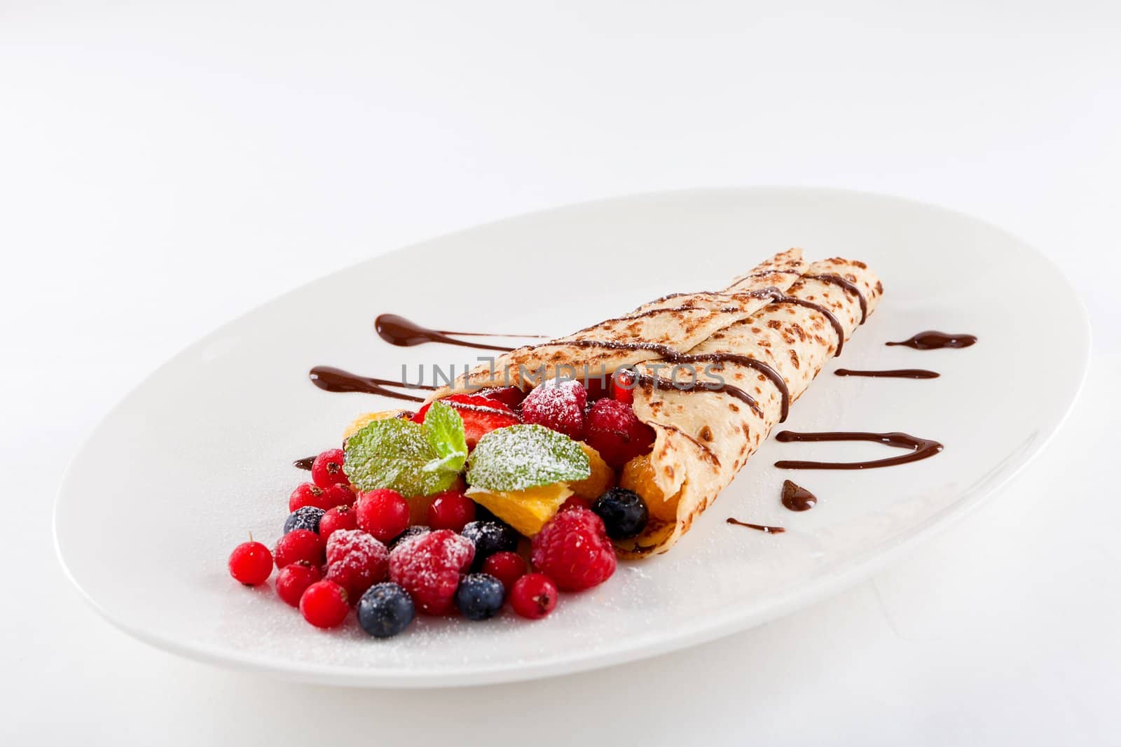 fresh tasty homemade crepe pancake with chocolate sauce fruits and berries