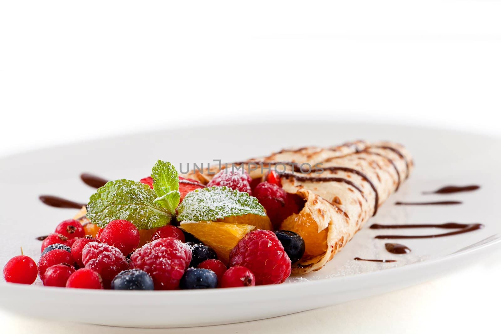 fresh tasty homemade crepe pancake with chocolate sauce fruits and berries