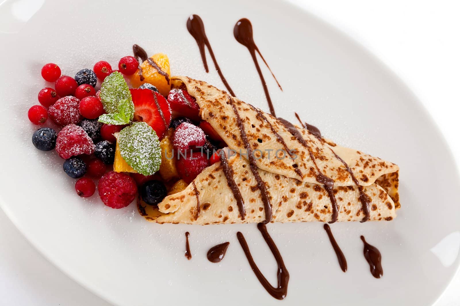 fresh tasty homemade crepe pancake with chocolate sauce fruits and berries