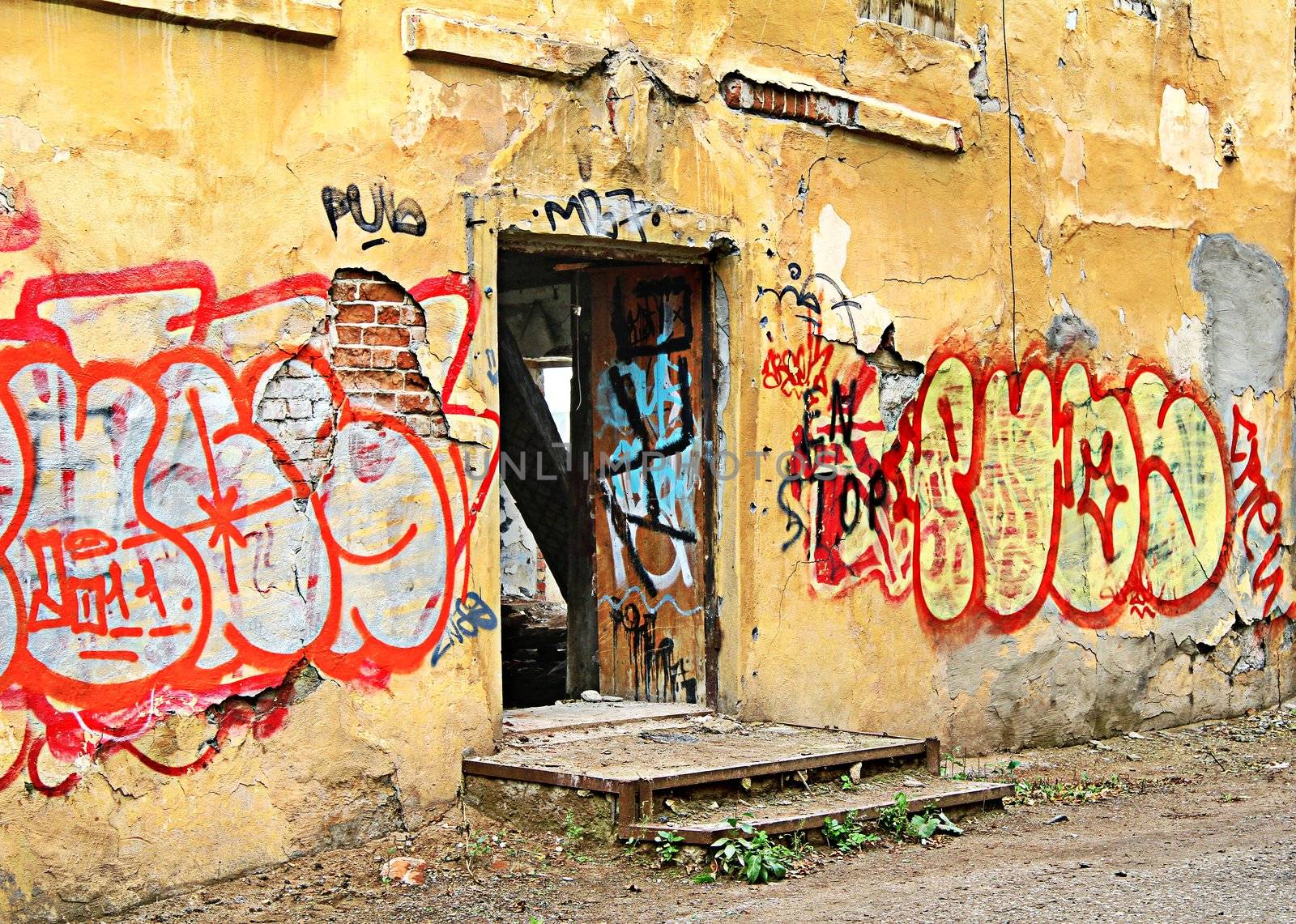 Old yellow wall with a graffiti