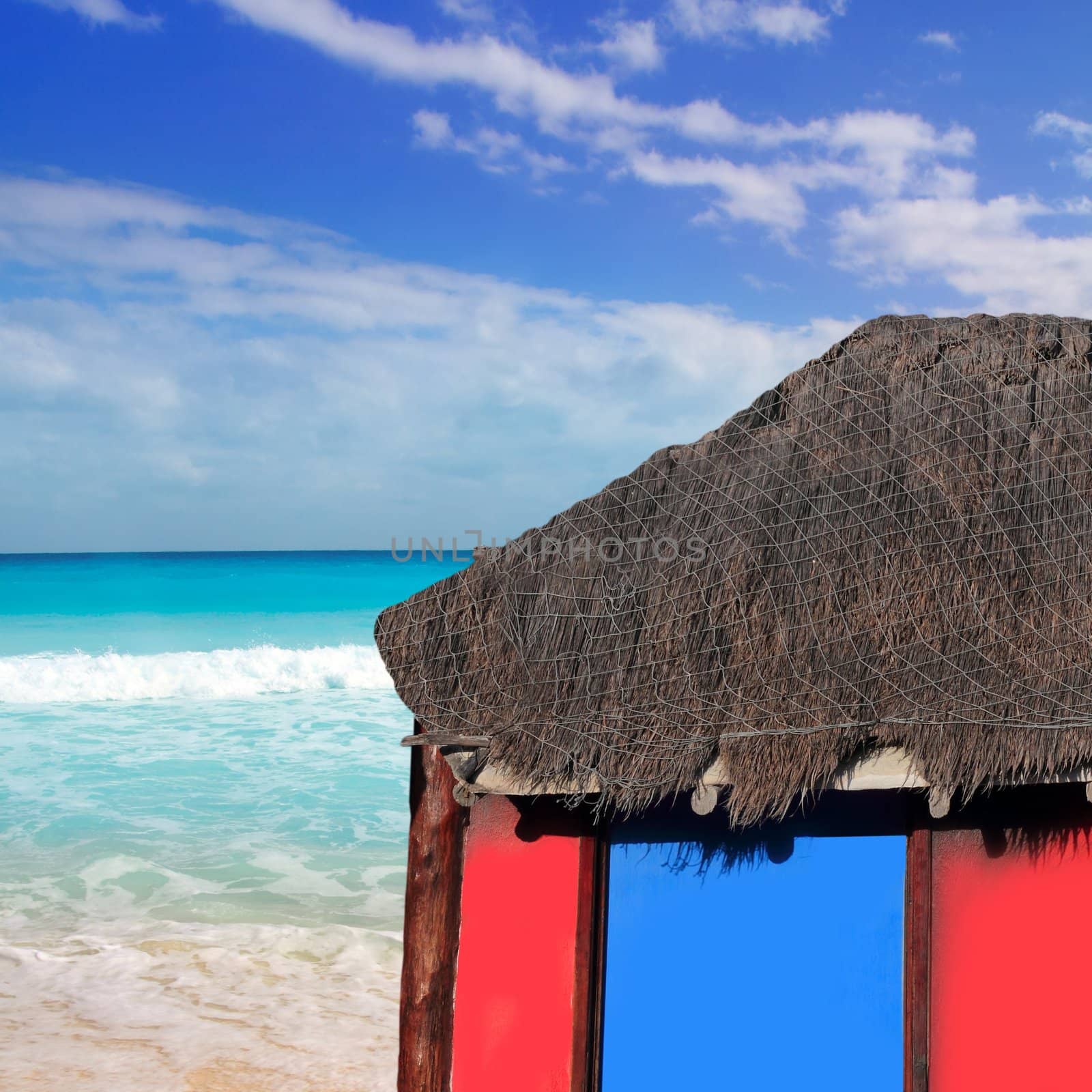 hut red palapa at turquoise beach of caribbean sea in a sunny blue sky day