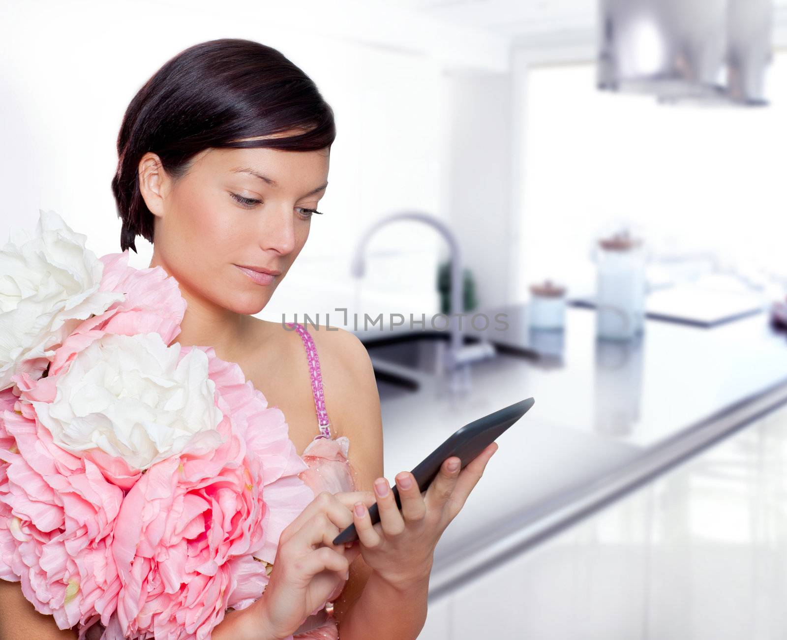 fashion woman and tablet ebook reading on kitchen with spring pink flowers dress