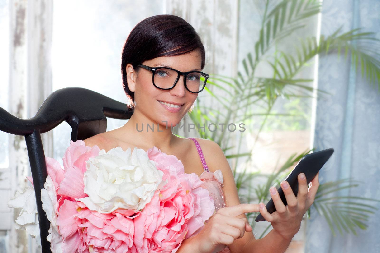 fashion woman and tablet ebook reading at home with spring pink flowers dress