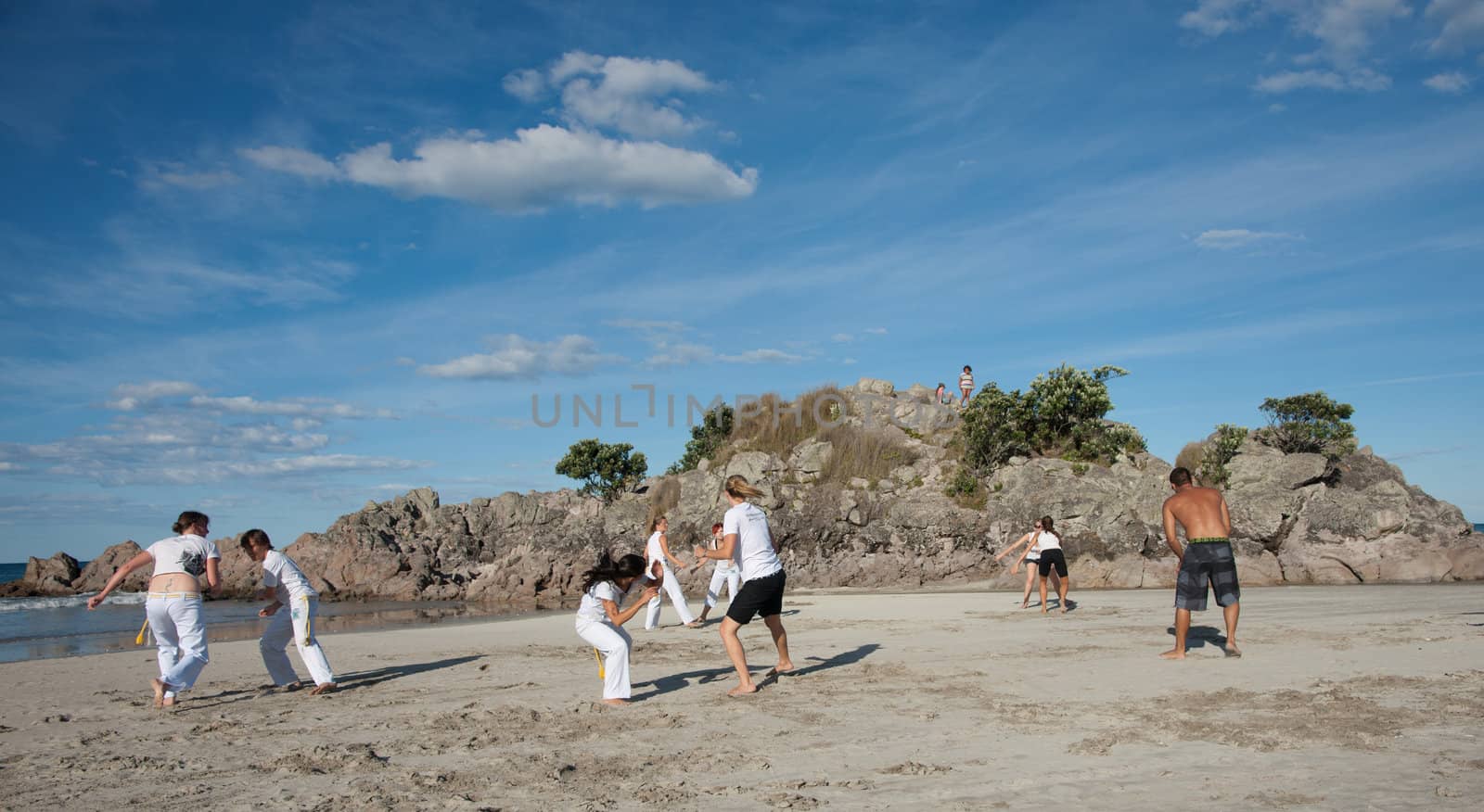 TAURANGA, NEW ZEALAND - JANUARY 23: Group of youths practice the art of capoeira on the Mount Maunganui beach, Tauranga New Zealand on January 23 2012. The sport, founded in Brazil is growing globaly.