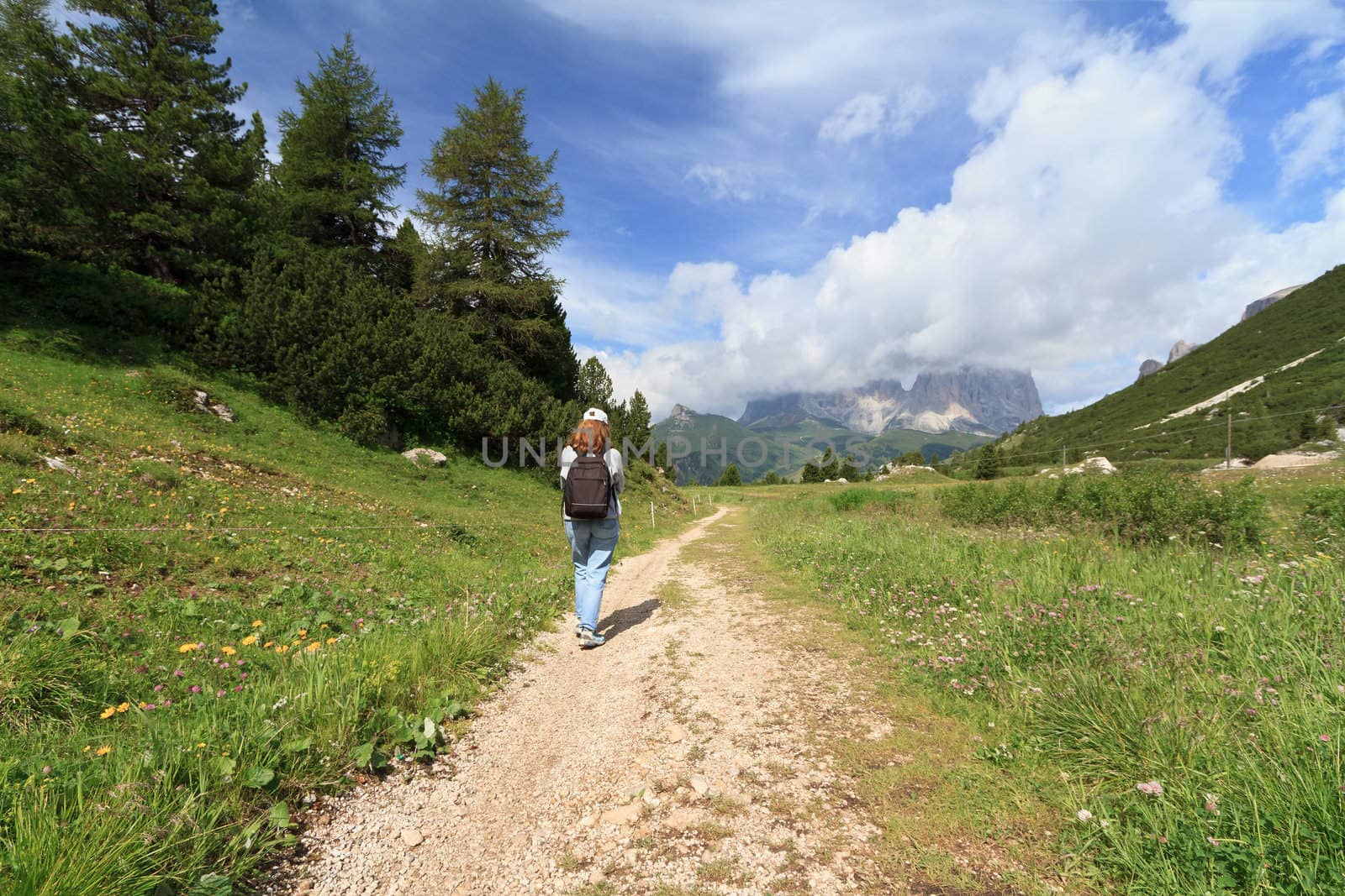 girl walking on a mountain path in Italian Dolomites