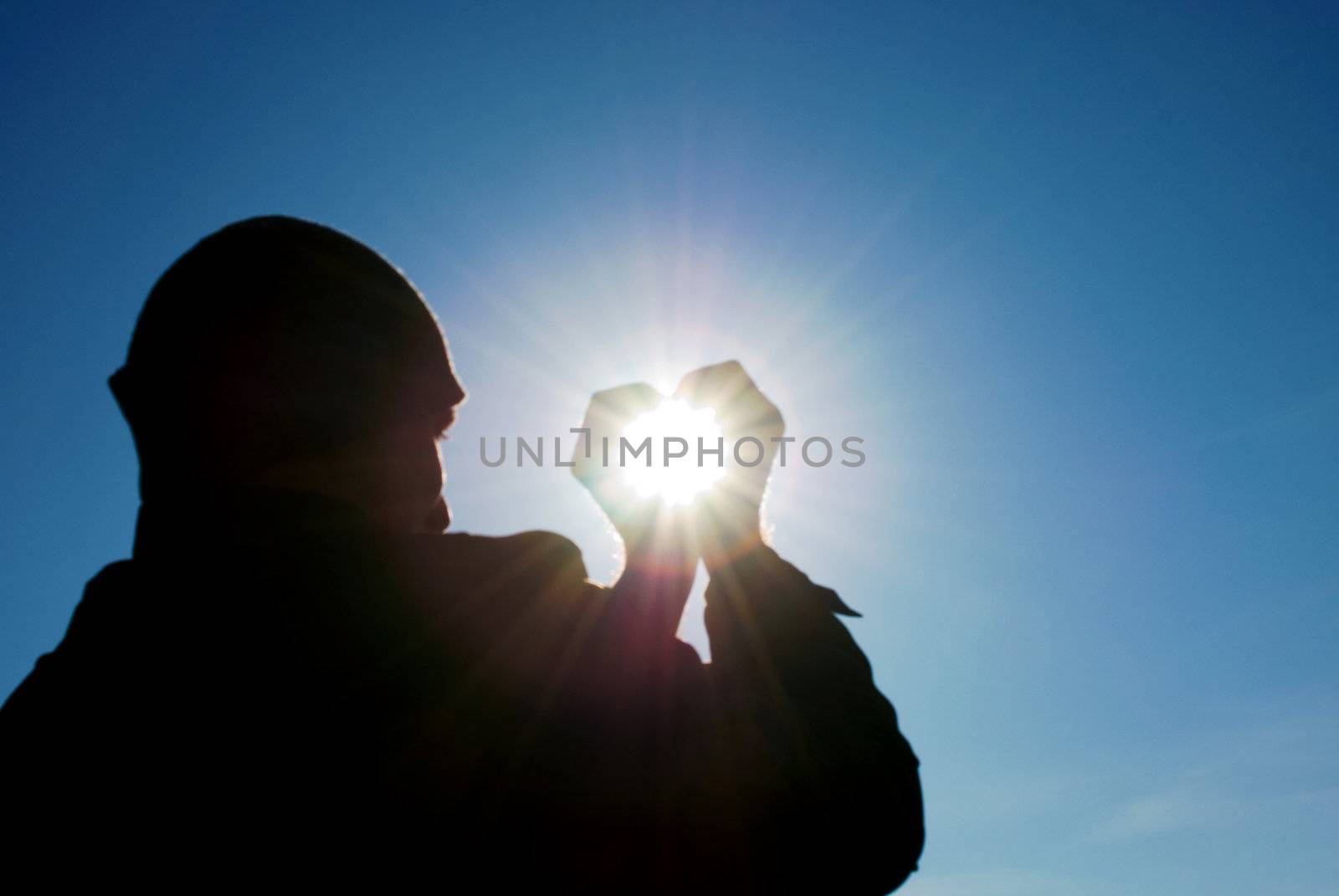 man holding a sun in his hands against the sky