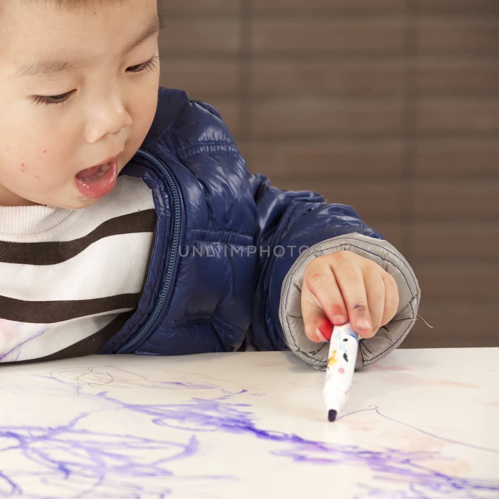 a cute baby is painting on the table by jackq