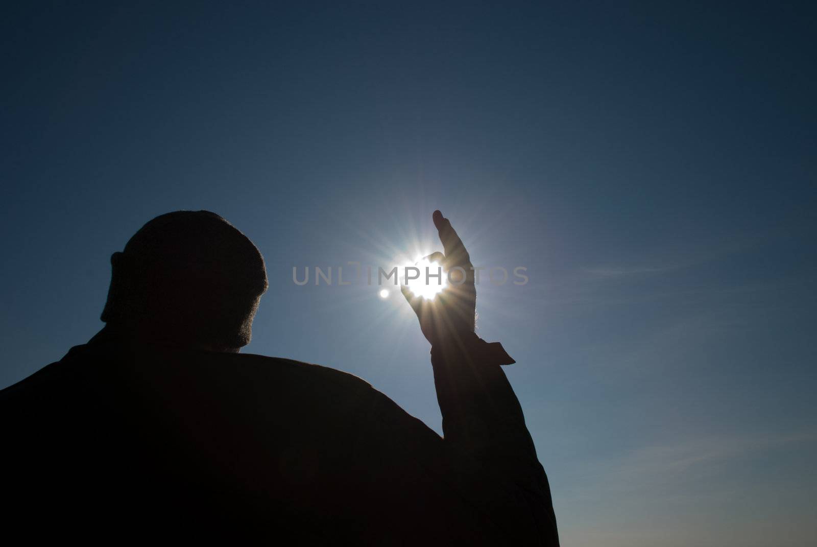 man holding a sun in his hands against the sky