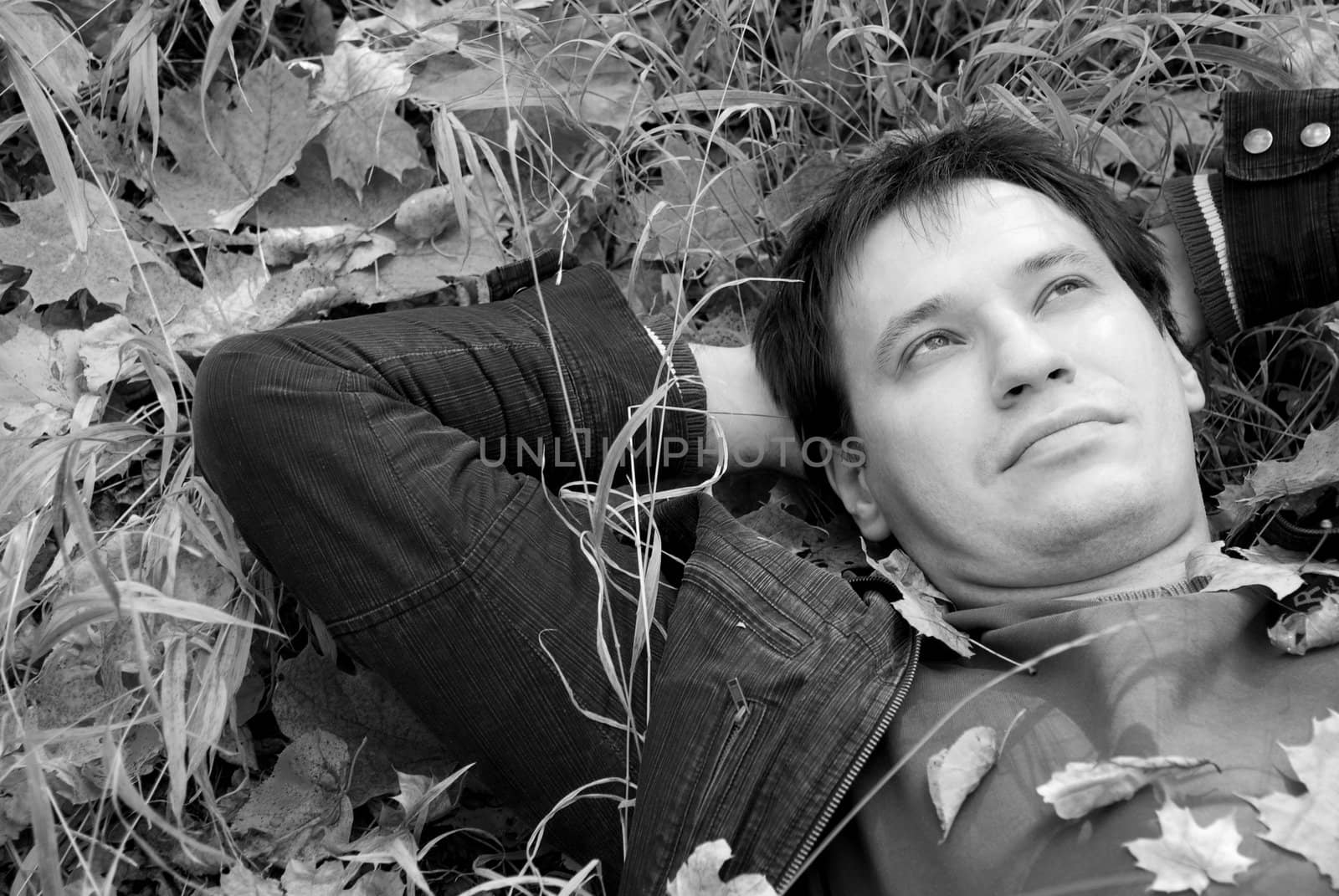 portrait of a man lying on autumn leaves