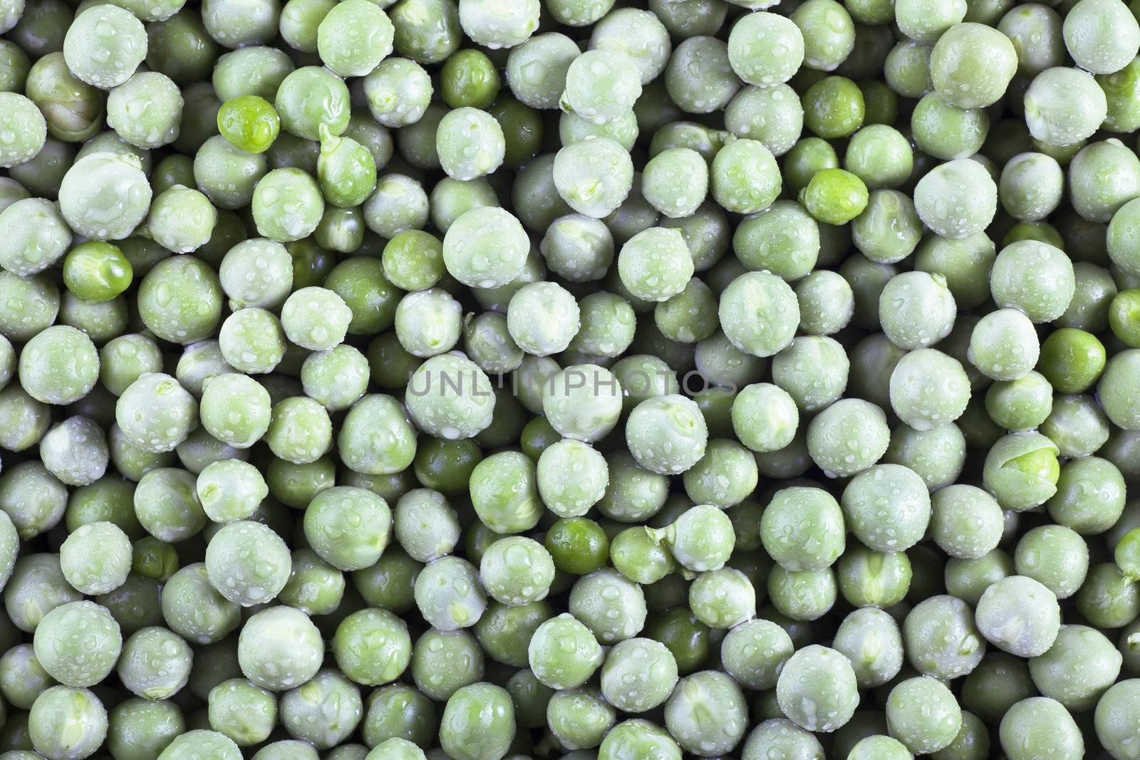 Fresh green peas covered with water drops, food background.