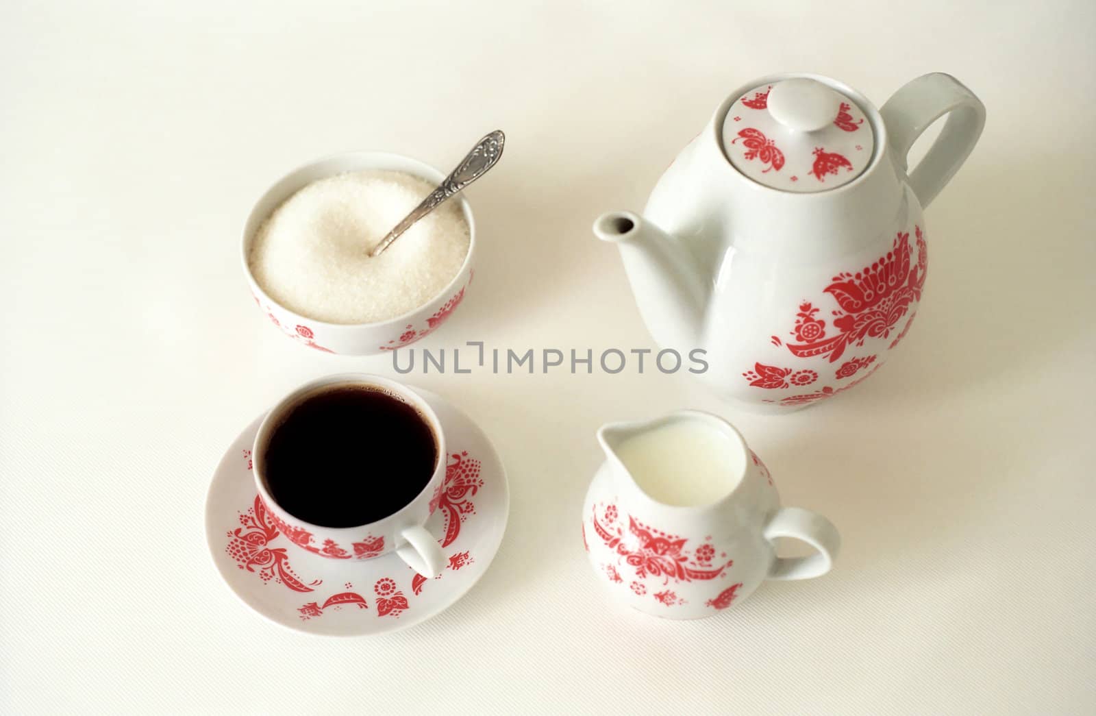 Coffeepot and a cup of coffee with milk and sugar