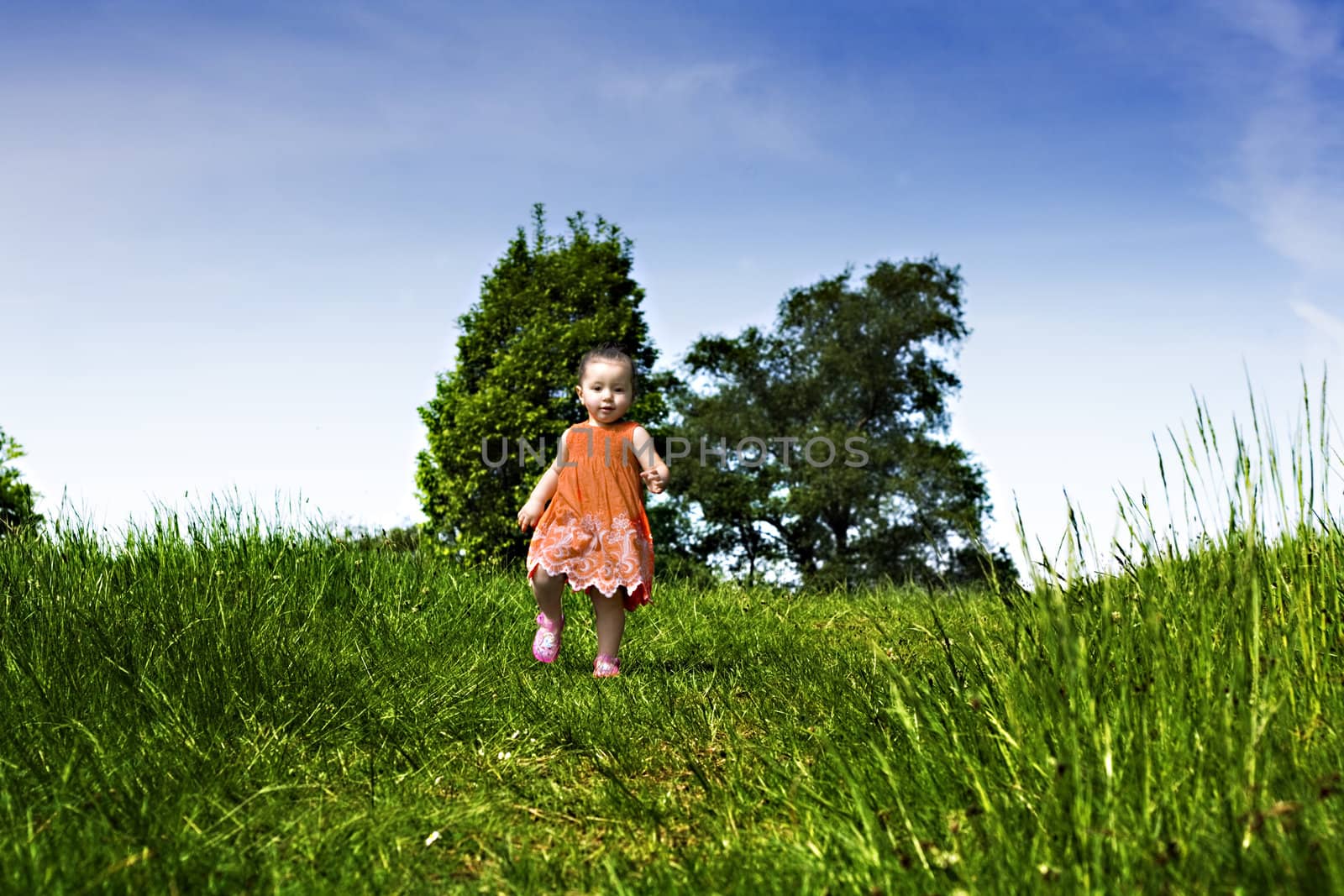 Baby girl running through the park by illu