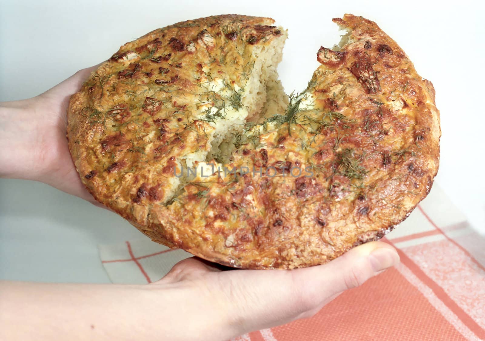 Breaking feta cheese bread in the hands close up